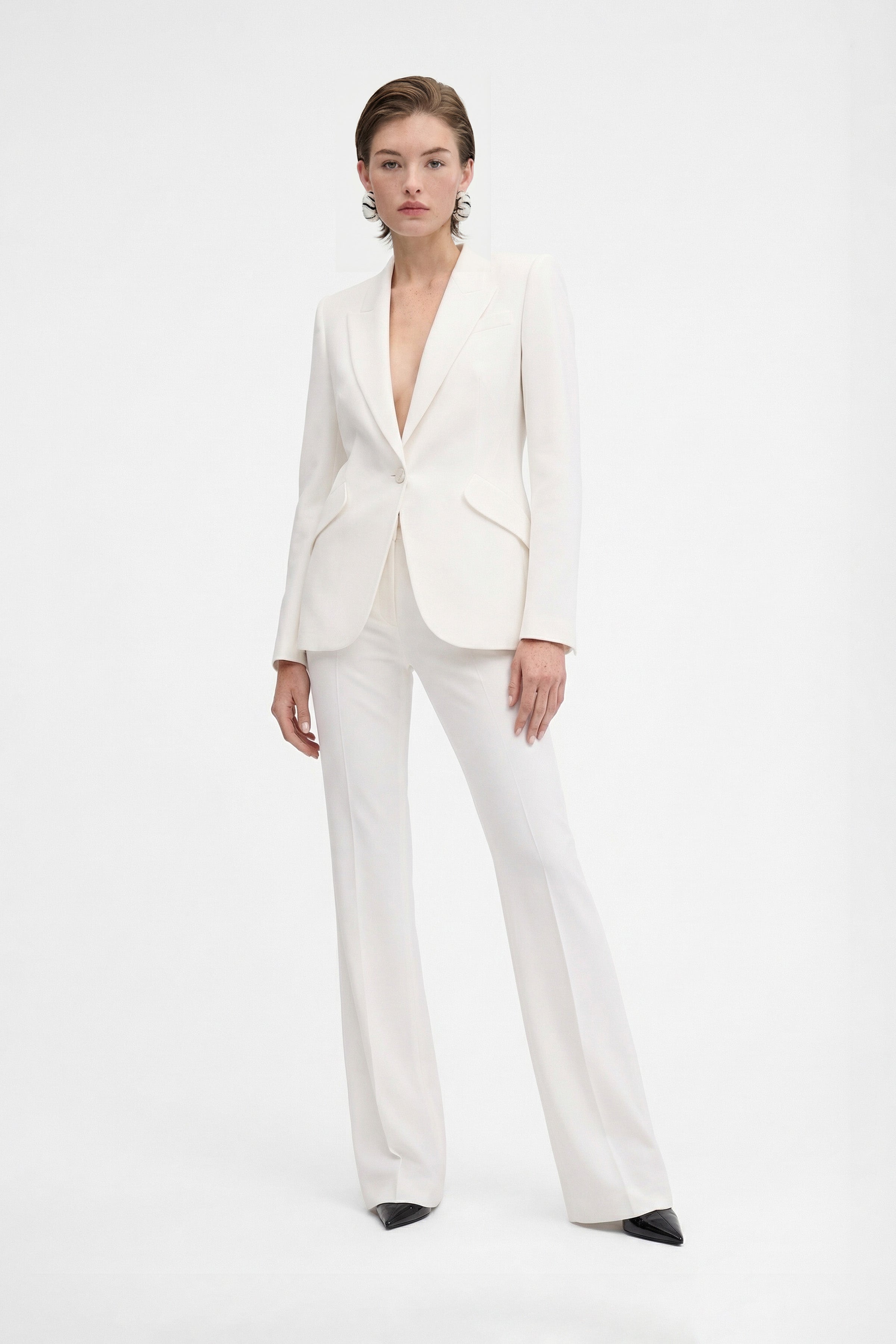 Front view of model wearing ivory tailored blazer, single-button closure and straight pants.