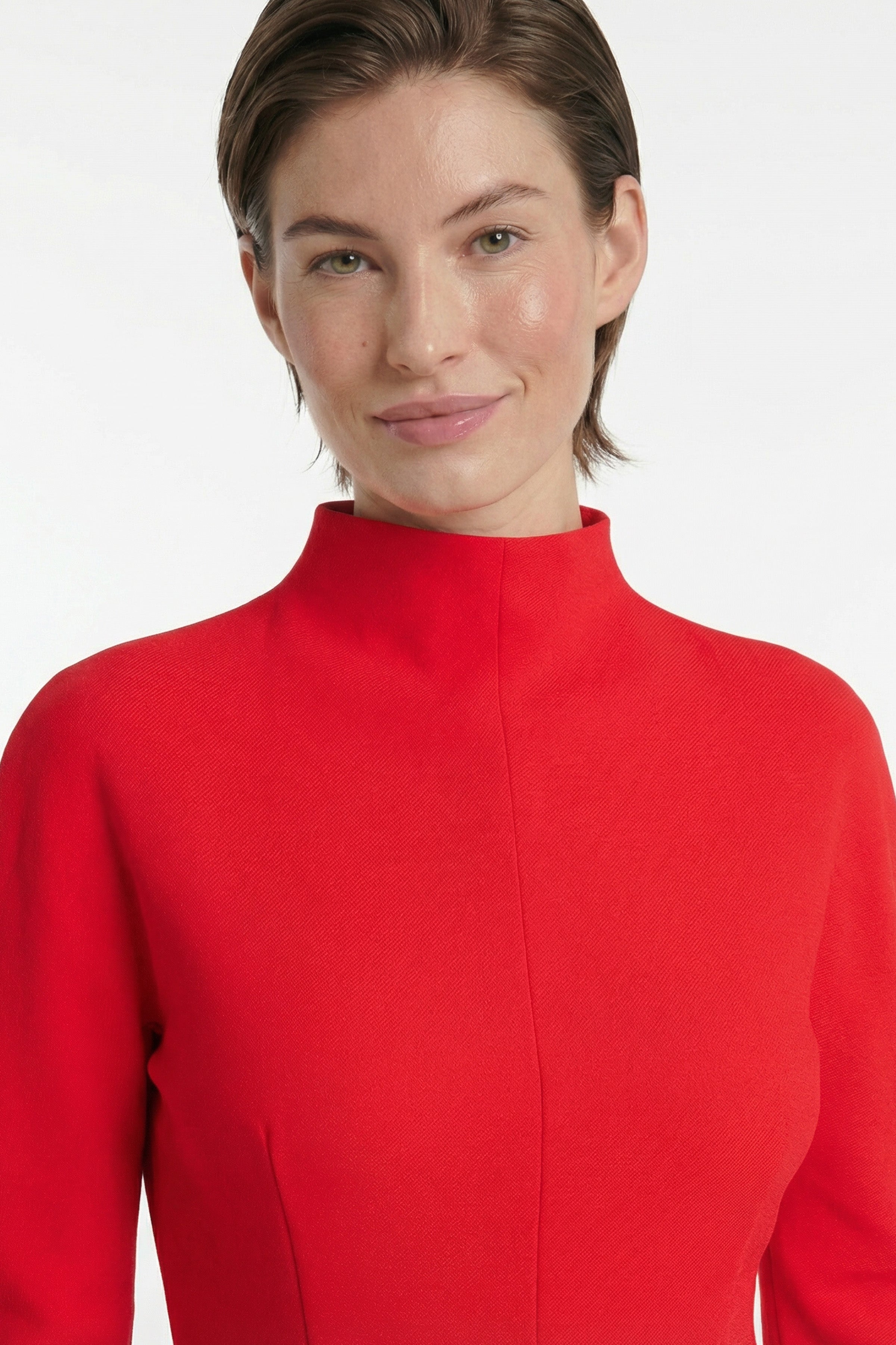 Close-up of a red structured mini dress with high neckline, modeled front view.