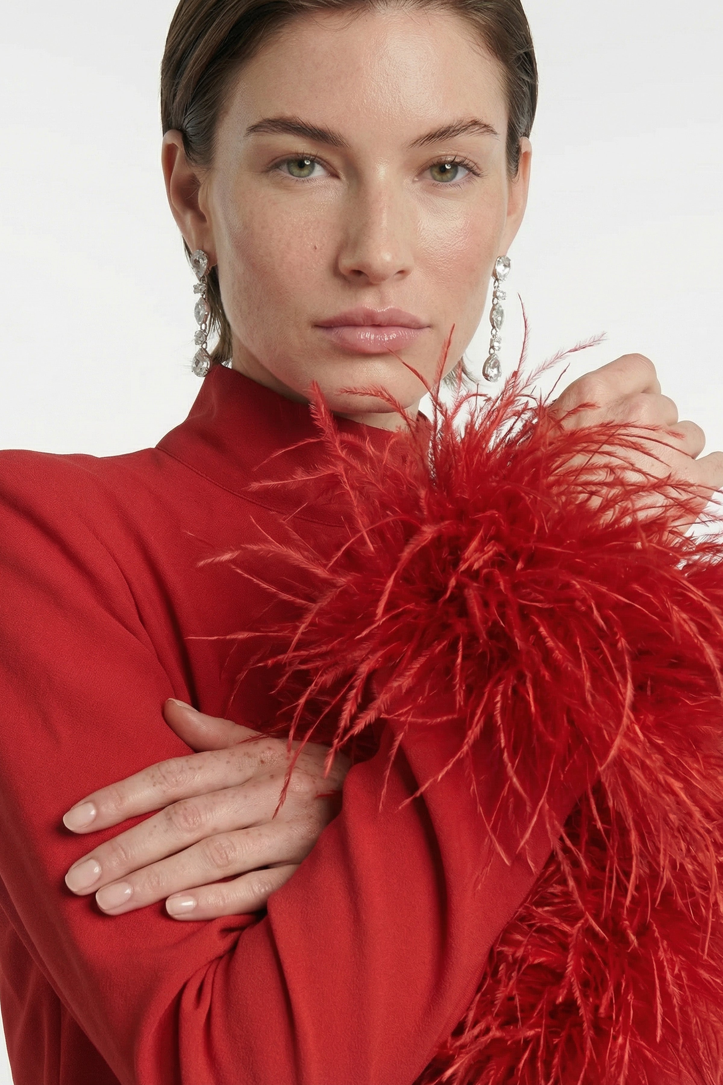 Close-up of feather trim on a red dress worn by a model.