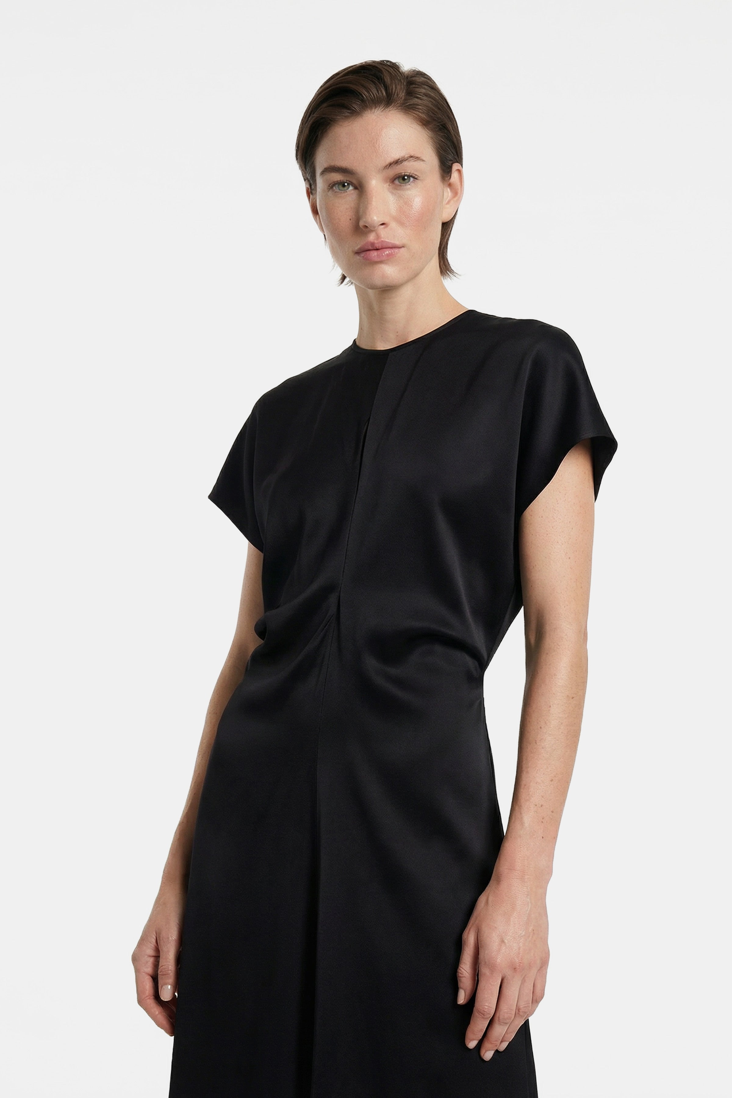 Model wearing sleek black maxi dress, front view, short sleeves, elegant drape.