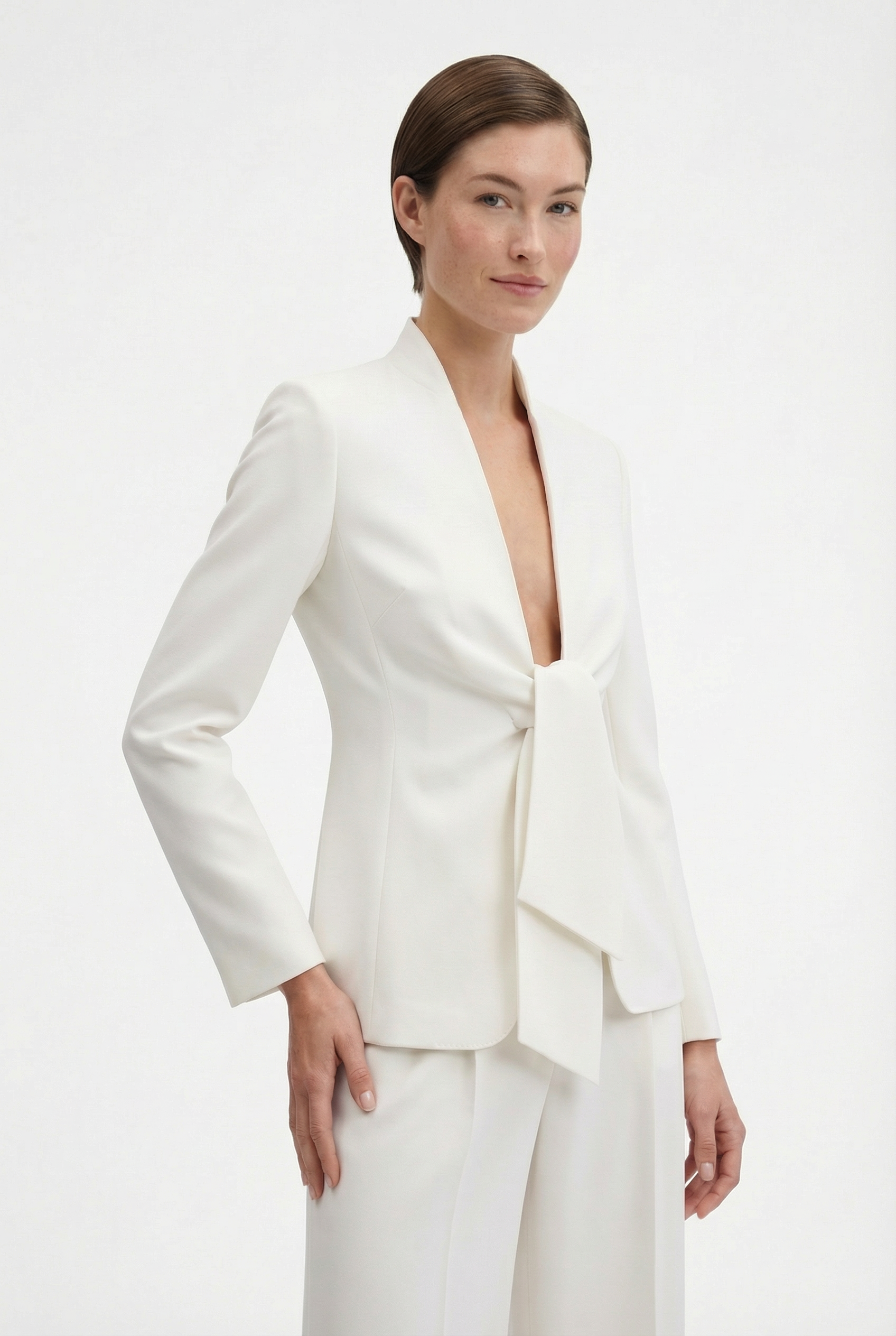 Model wearing ivory suit with tie-front detail, front view.