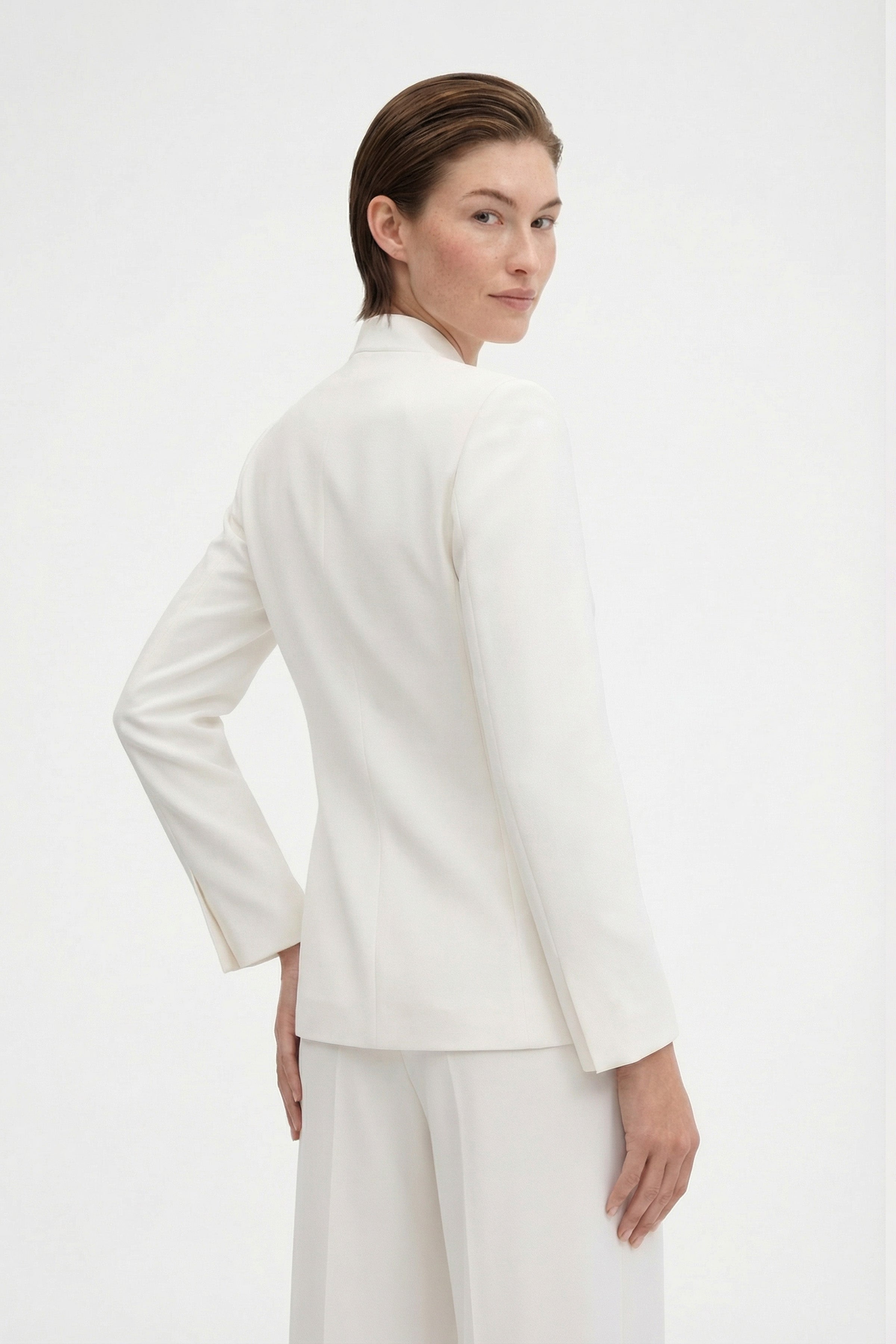 Back view of model wearing an ivory tie-front suit, showing sleeve detail.