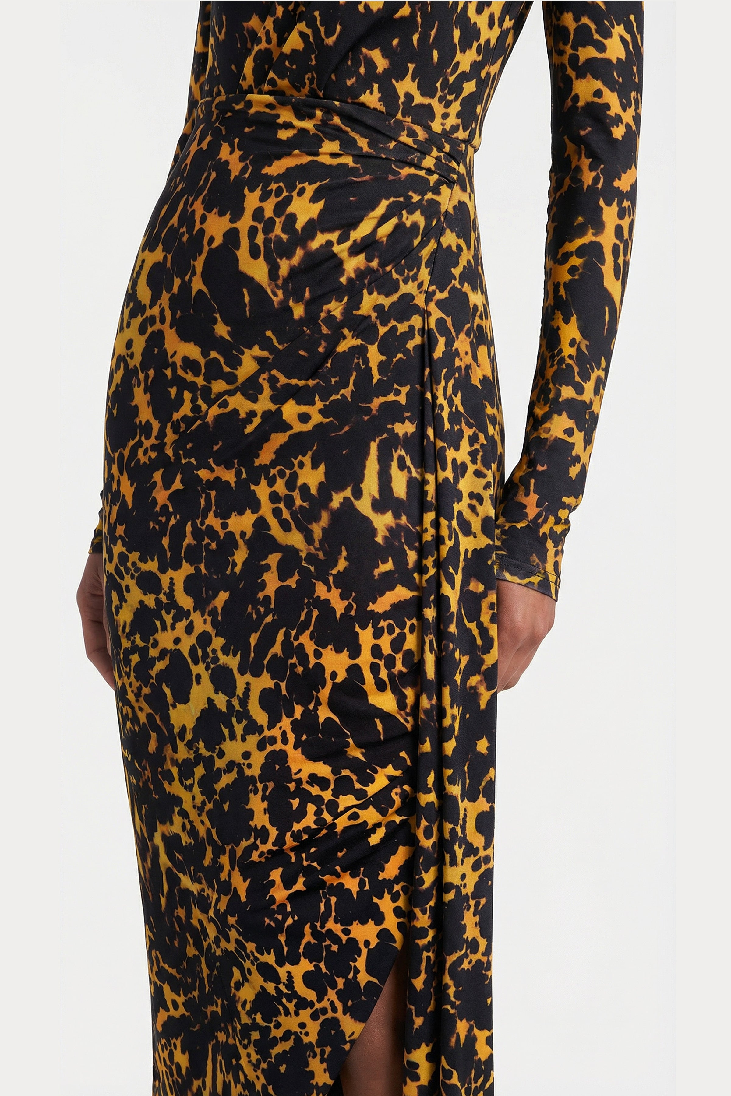 Detail shot of elegant side draping and abstract leopard-inspired pattern on a modern long-sleeved evening dress.