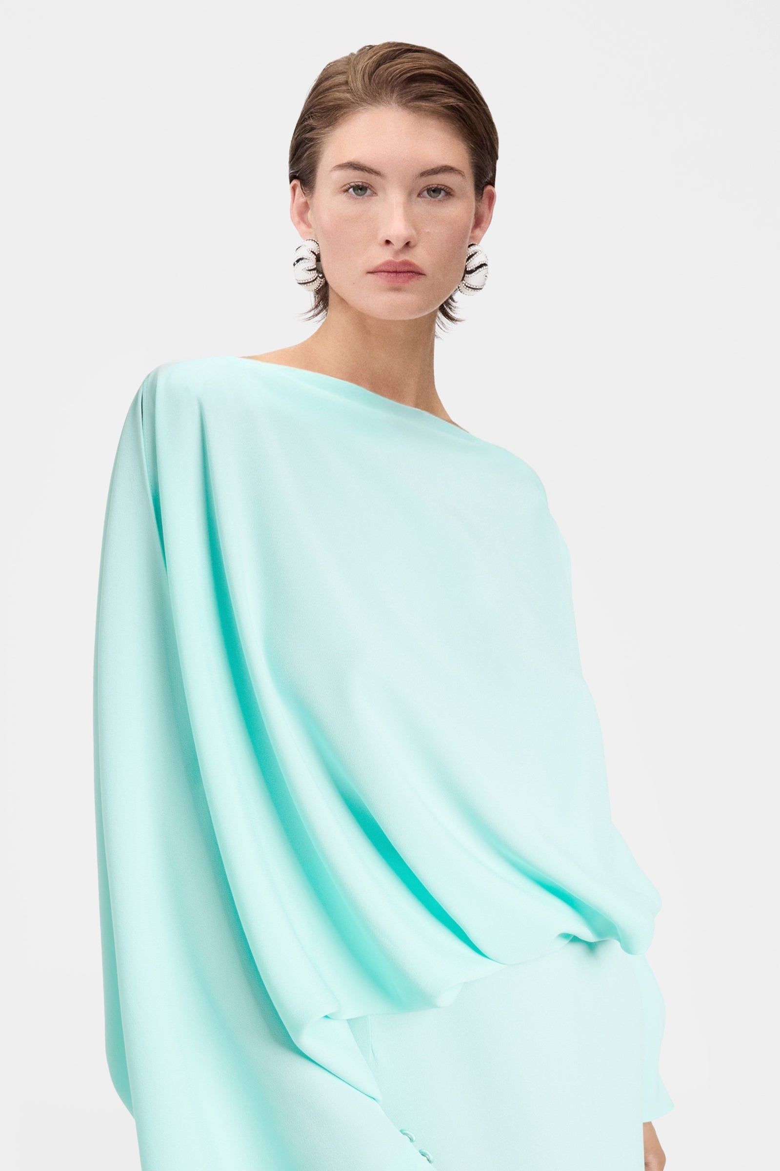 Elegant green draped dress with sculptural top and flowing maxi skirt close view