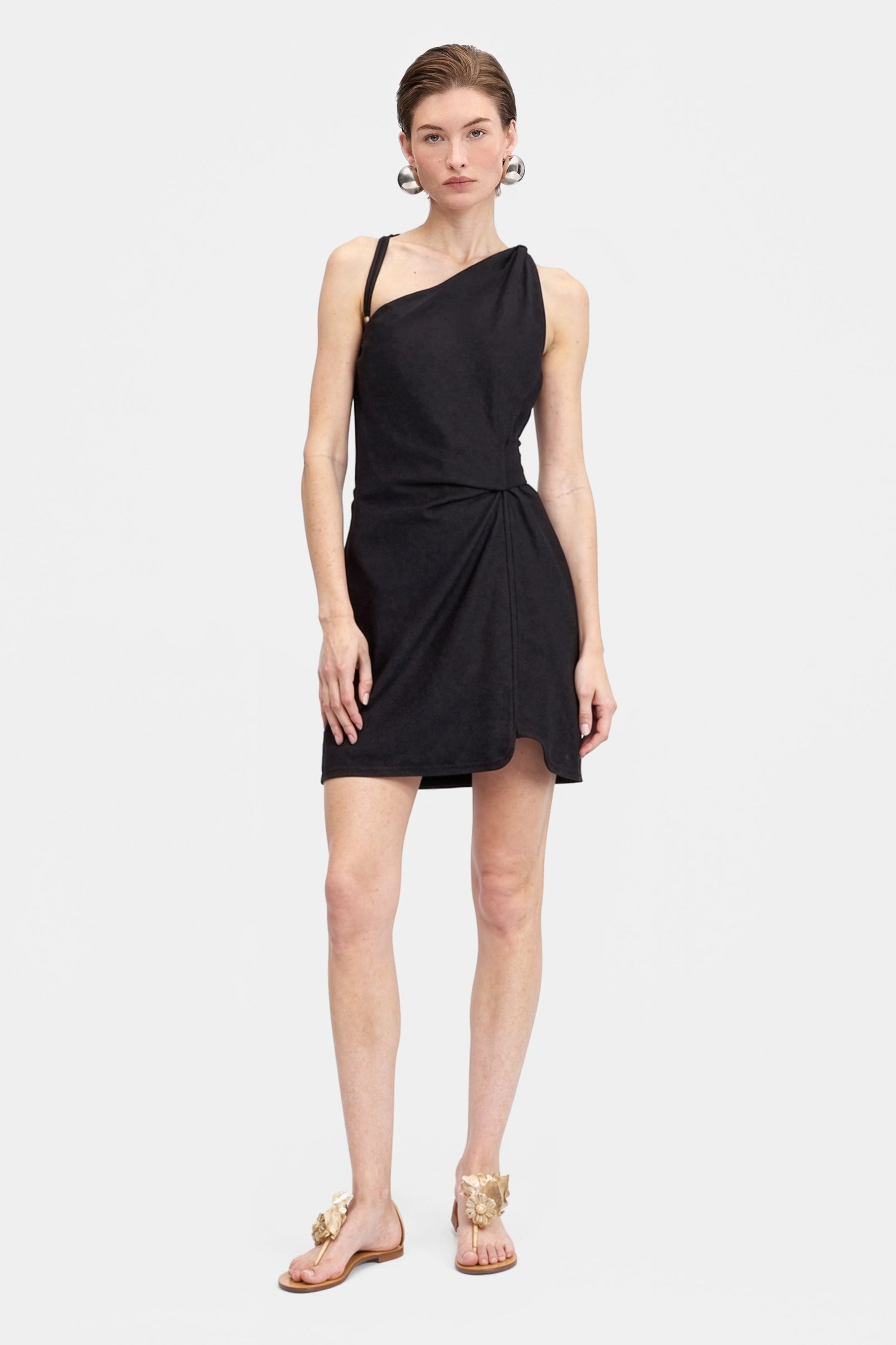 Woman wearing a black one-shoulder linen dress