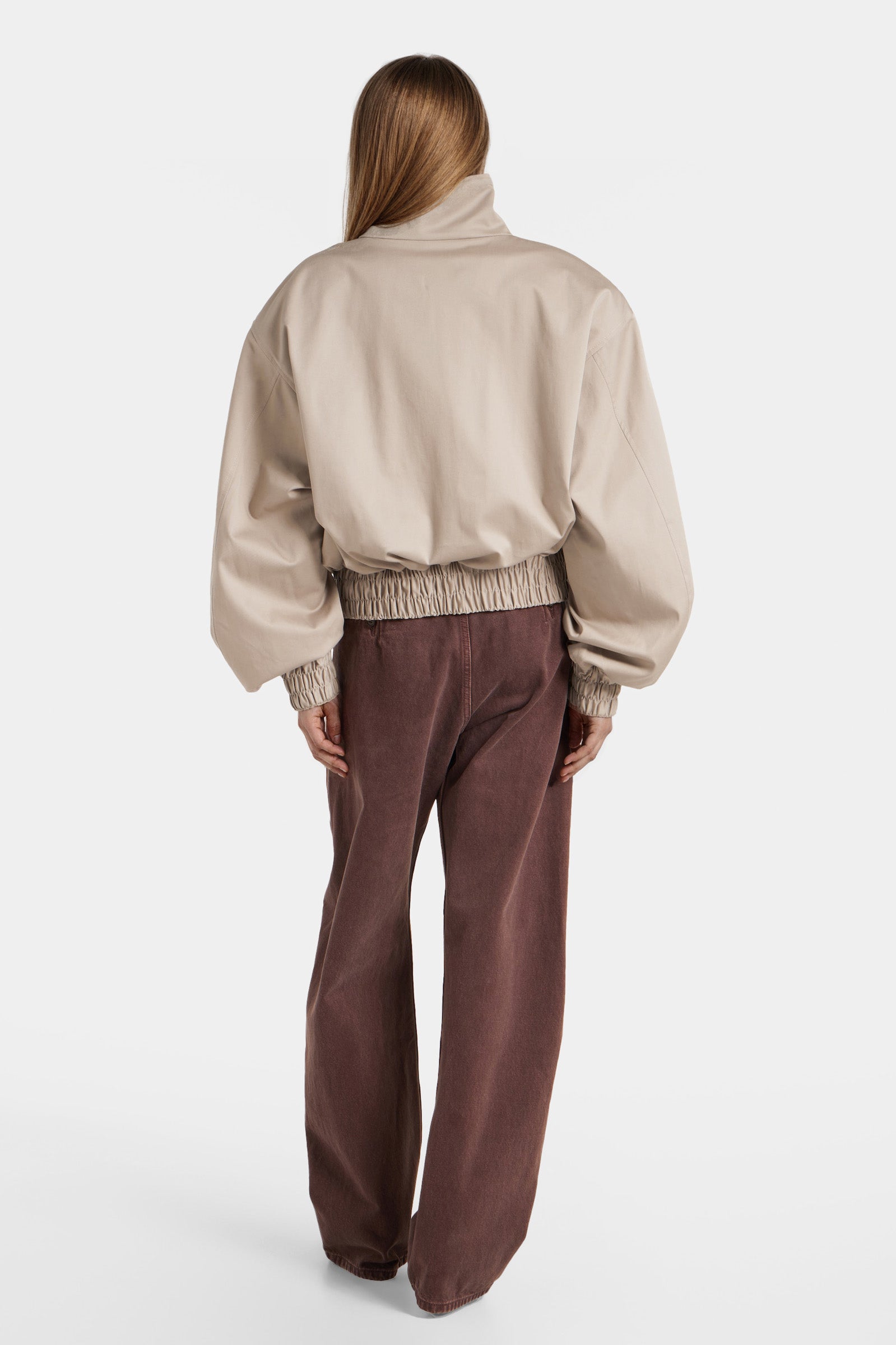 Back view of oversized beige bomber jacket with high collar