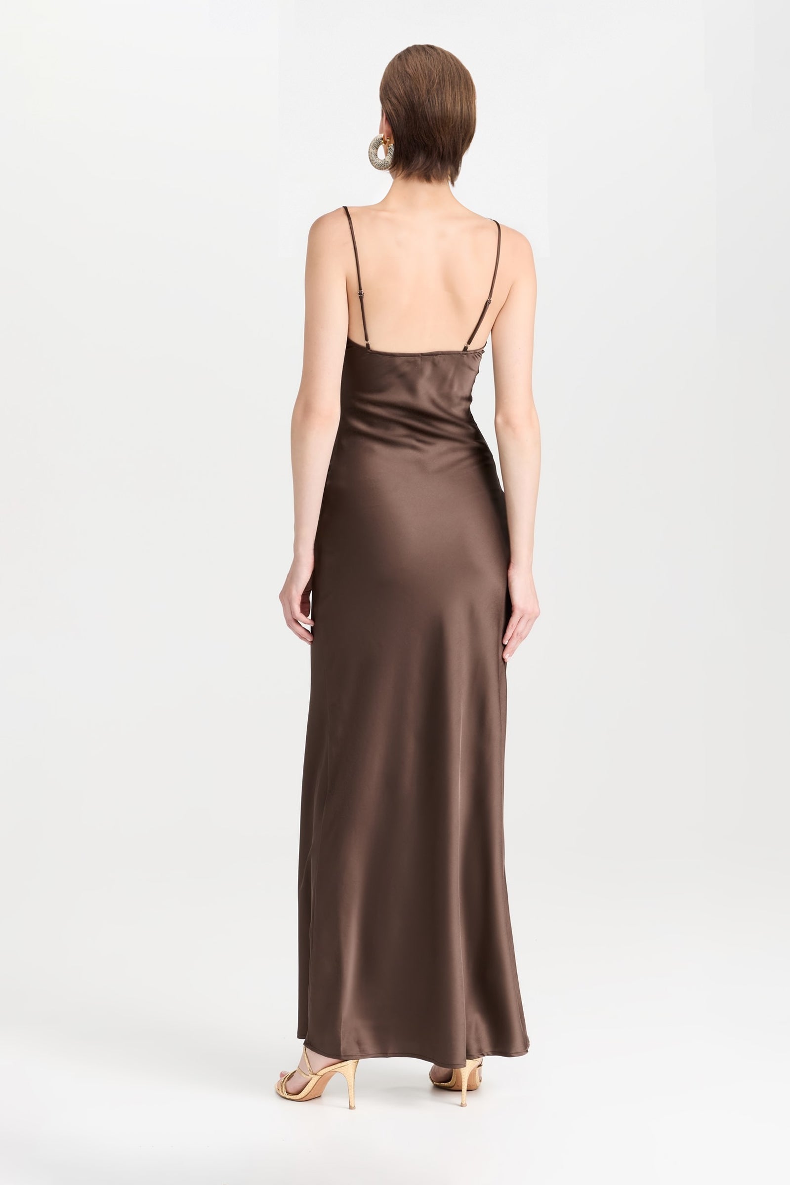 Shiny chocolate brown satin dress in a flattering maxi length, showing off its draped fabric and front lacing detail.