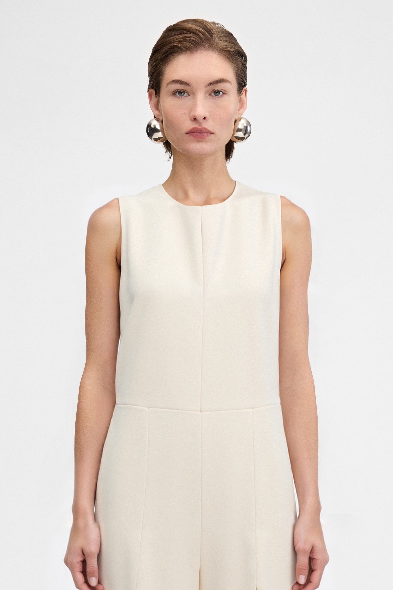 Close up profile of elegant cream jumpsuit showing fluid crepe fabric