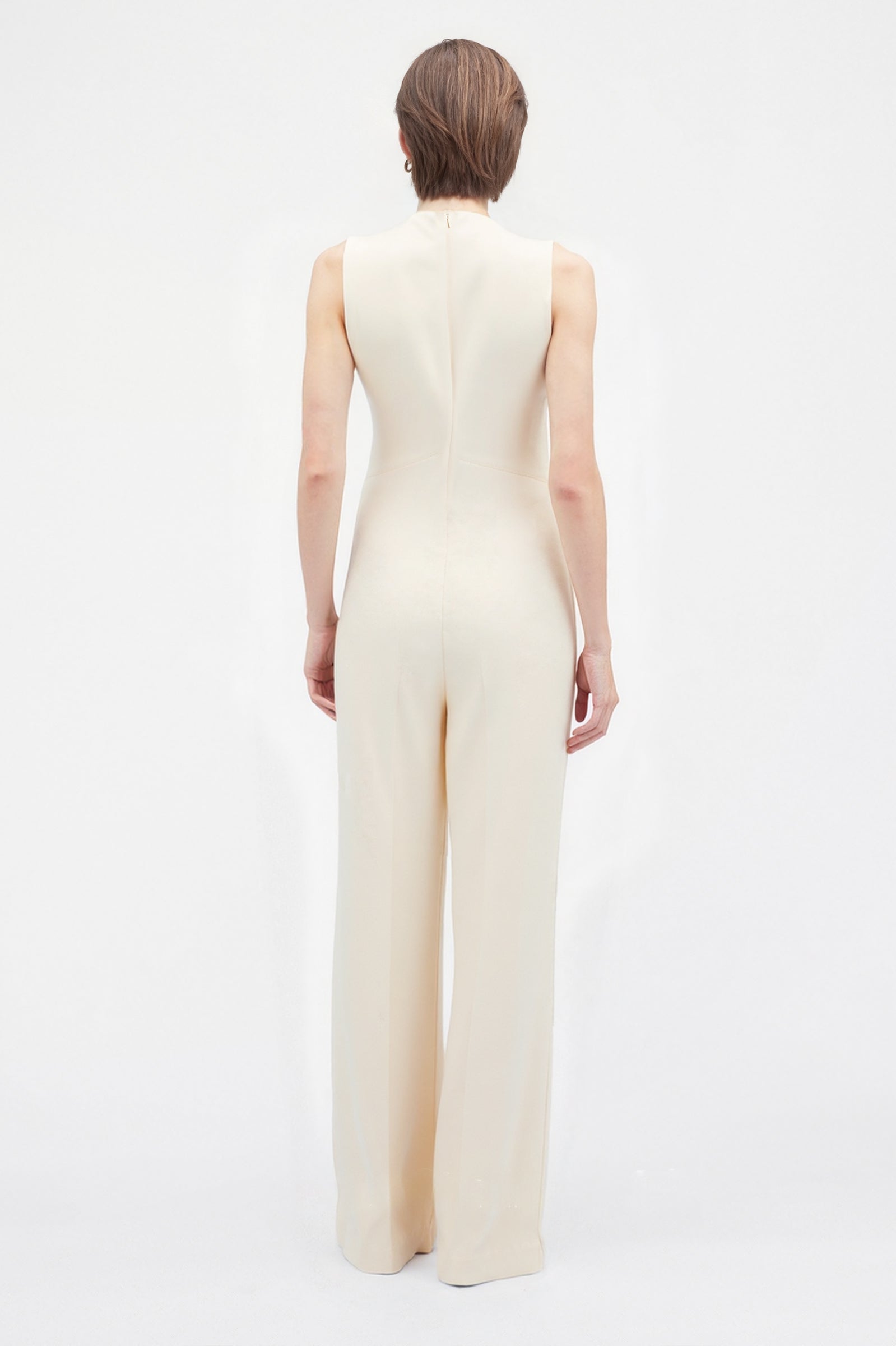Back view of minimalist cream jumpsuit with invisible zipper closure