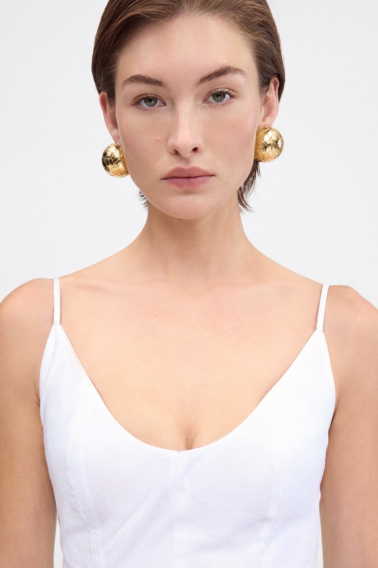 Close-up of the crisp white poplin cotton fabric and the gathered, flared hem of the mini dress.