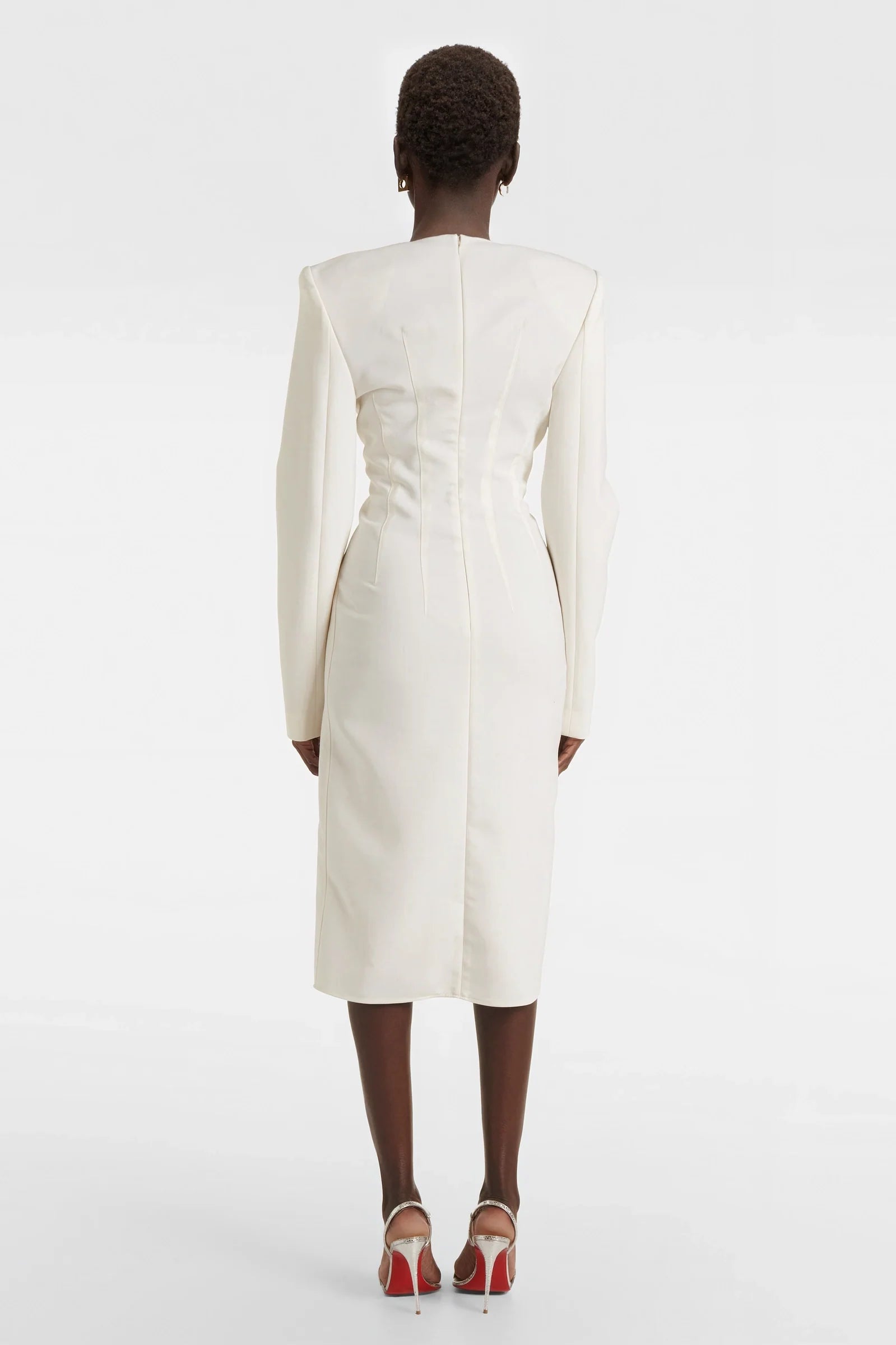 Elegant white structured dress styled with metallic accessories