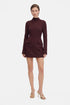 Model wearing burgundy mini dress with long sleeves, structured fit, and front pockets.