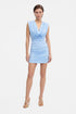 Model wearing a sky blue draped mini dress, front view, minimal background.