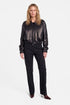 Model wearing black leather bomber jacket, front view, standing.