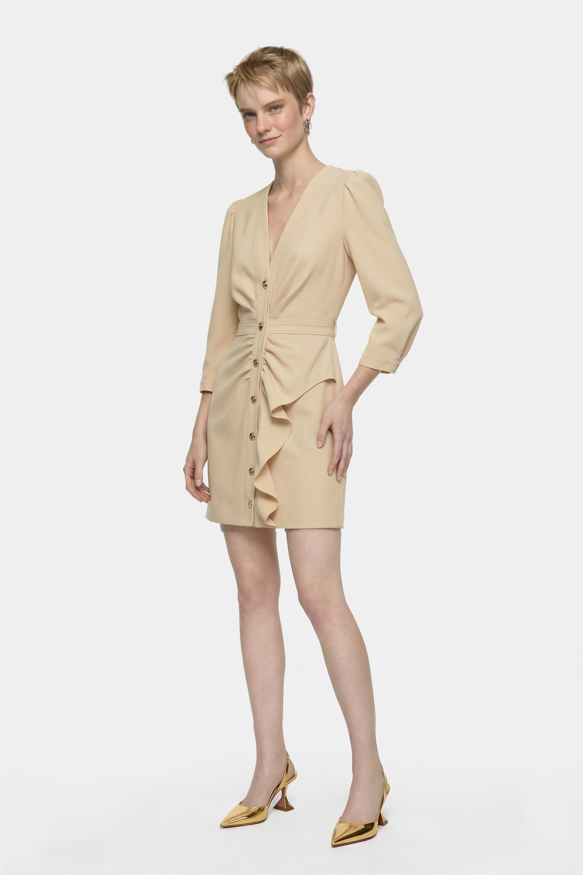 Elegant ruffle button dress, front view, model poses wearing gold heels, neutral background.