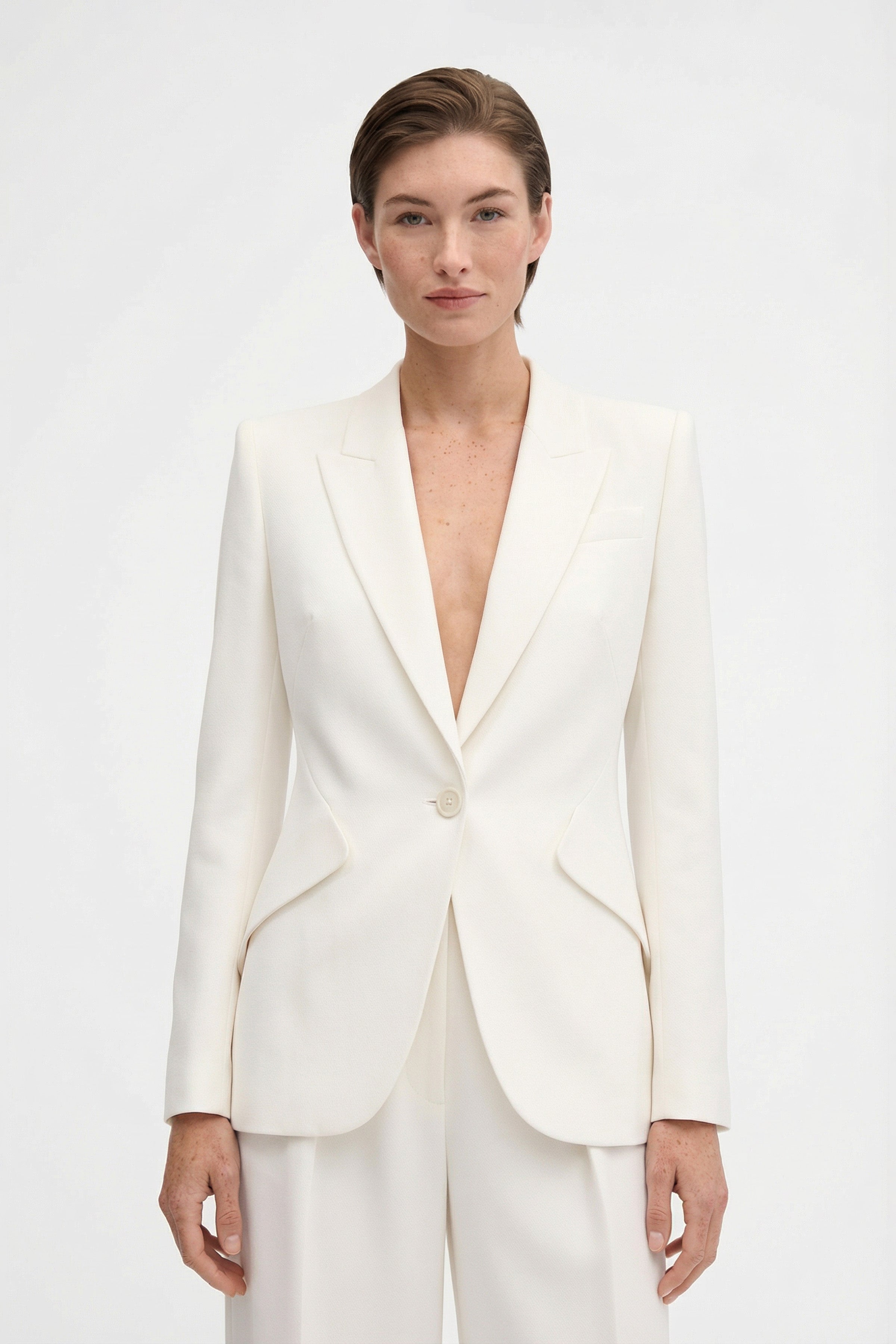 Front view of model wearing ivory tailored blazer, single-button closure.