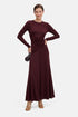 Model wearing burgundy ruched long sleeve dress, front view, holding small clutch.