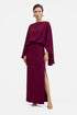 Model wearing a burgundy draped slit gown with flowing sleeves, front view.