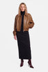Model wearing cognac leather bomber jacket, front view, paired with black dress.