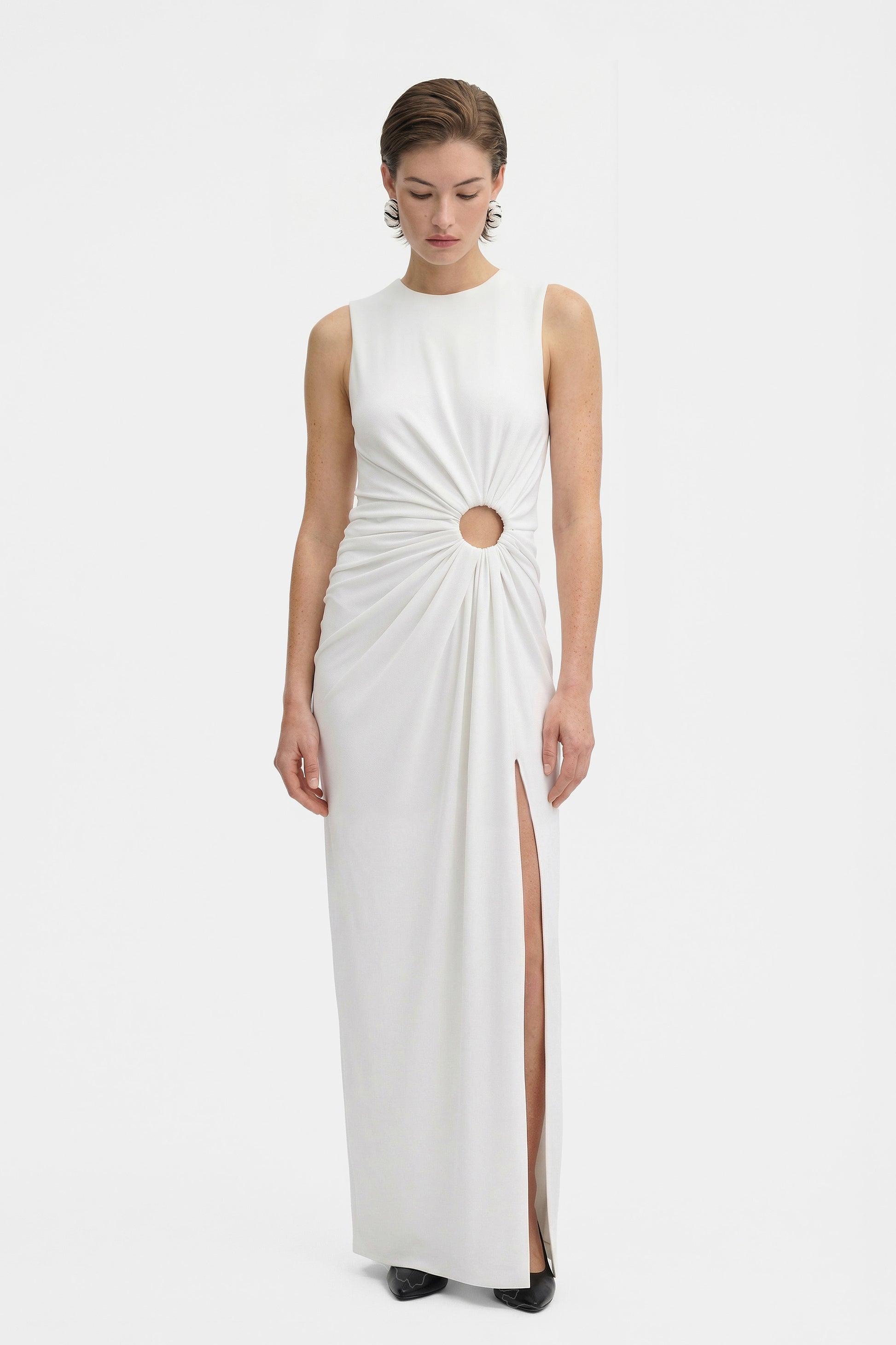 Front view of white gown with cut-out detail and thigh-high slit.