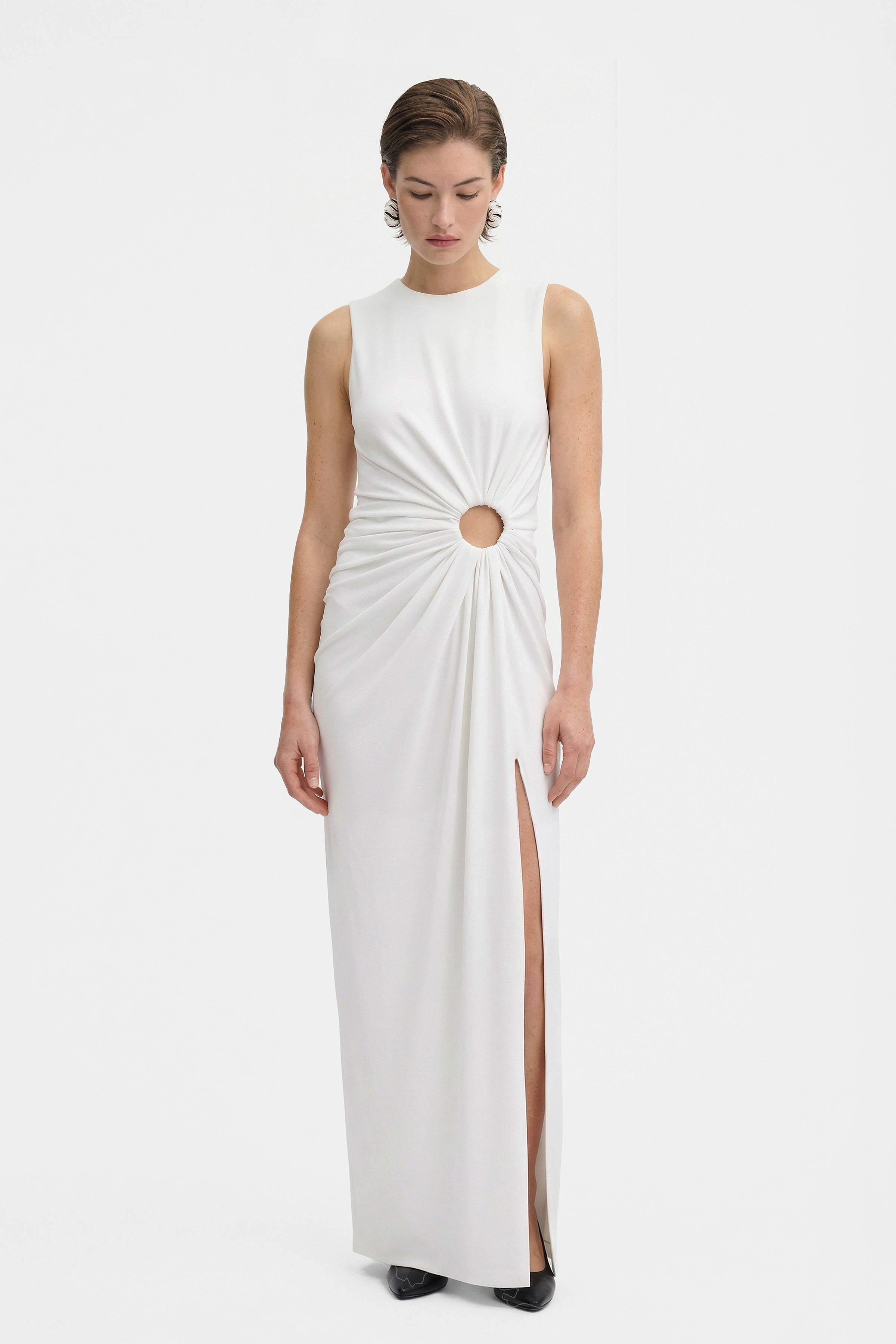 Front view of white gown with cut-out detail and thigh-high slit.