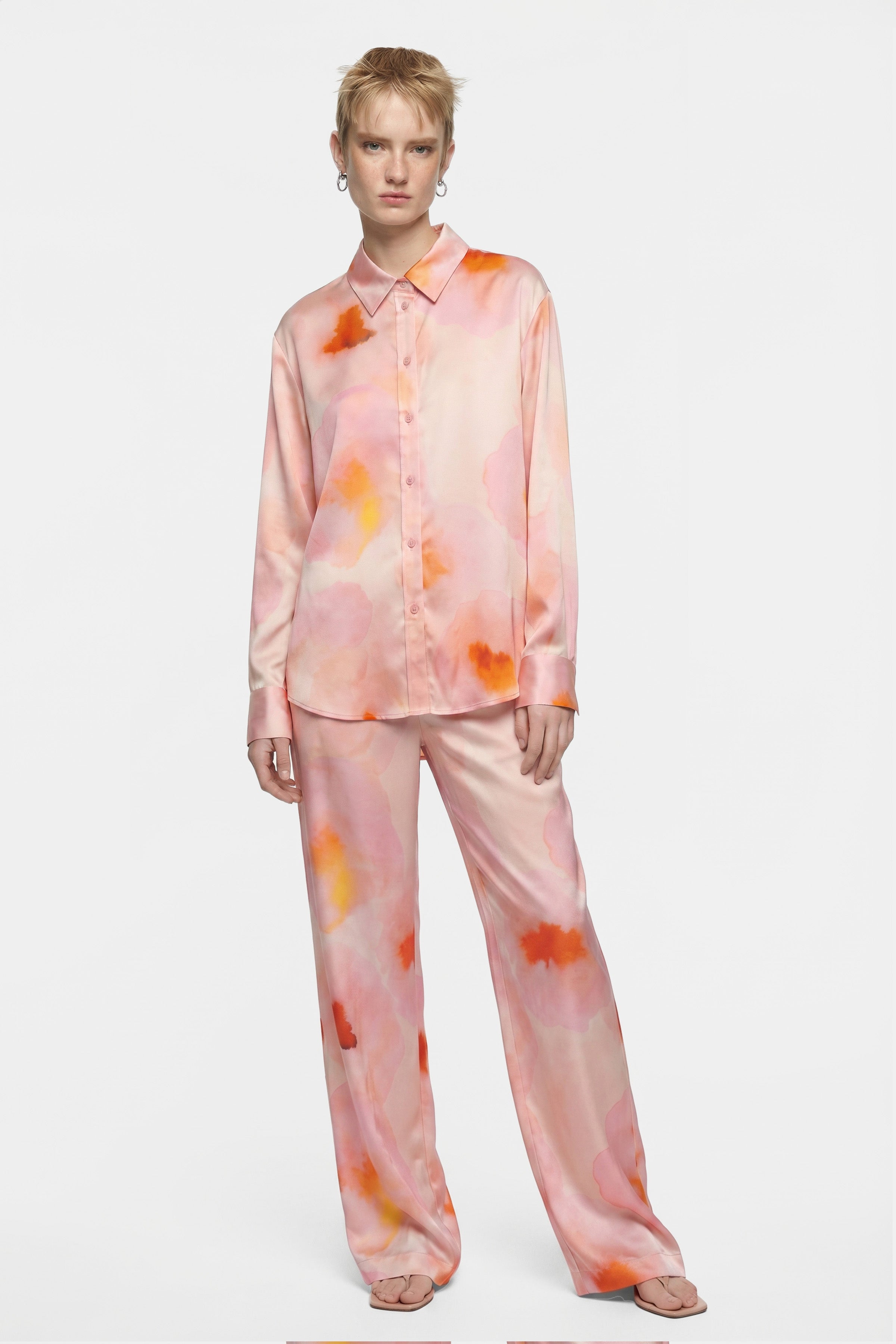 Model wearing front view of watercolor silk set with pink, orange patterns.