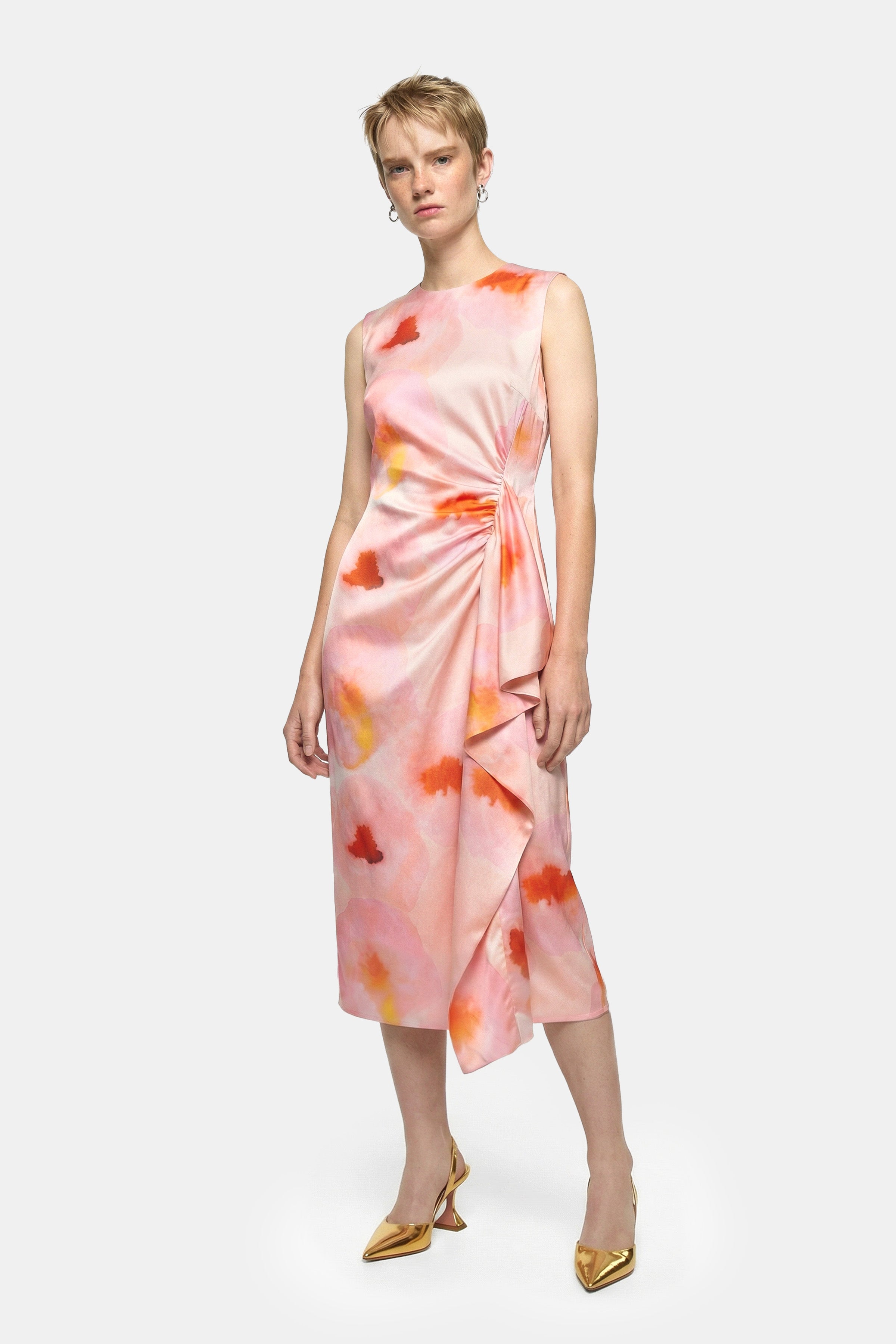 Model wearing sleeveless watercolor print midi dress, front view, with asymmetric draping detail.