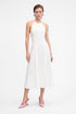 White halter midi dress, front view, modeled with pink shoes, minimal backdrop.