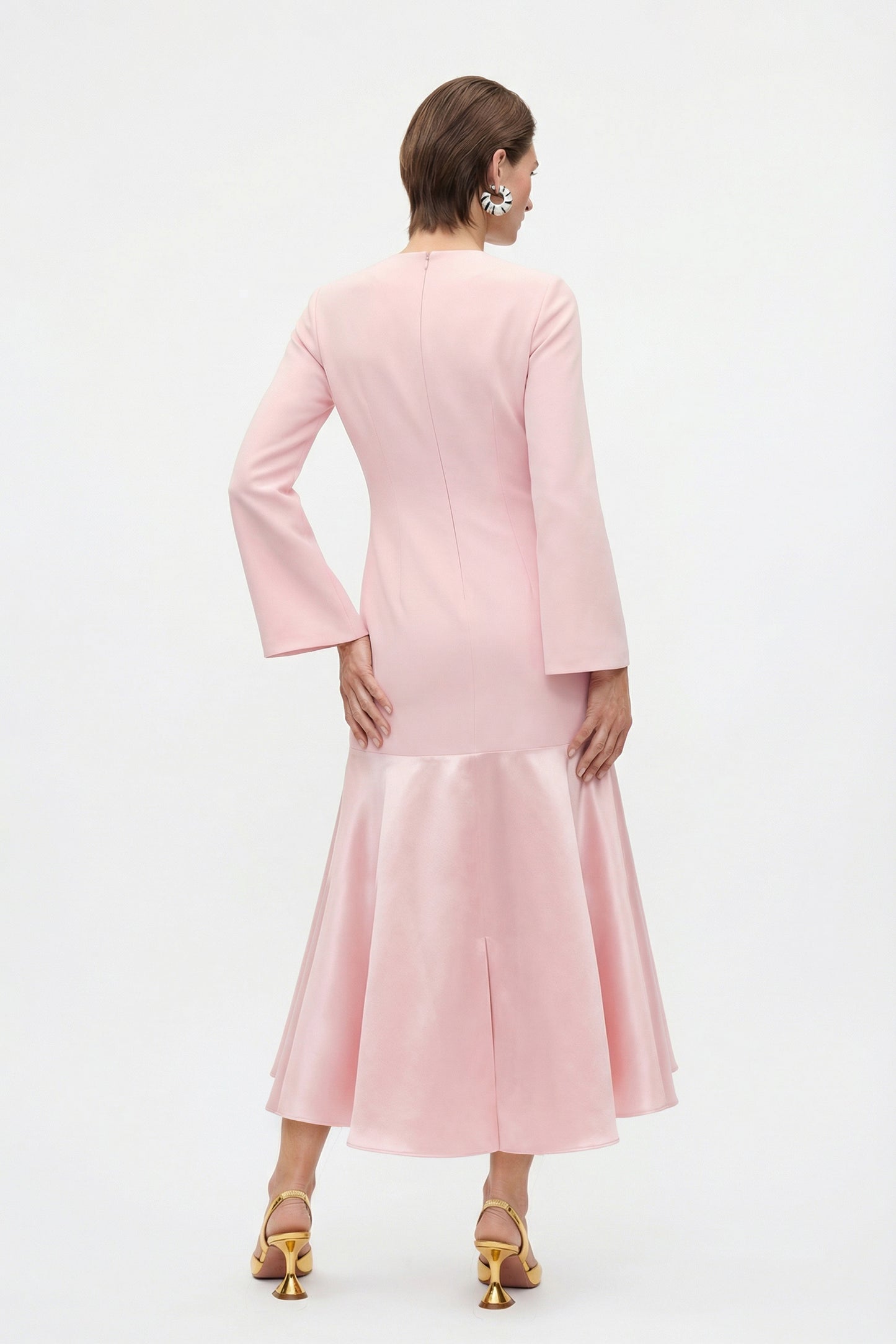 Back view of the model wearing the pink dress, highlighting the flowing silhouette and ankle-length cut.
