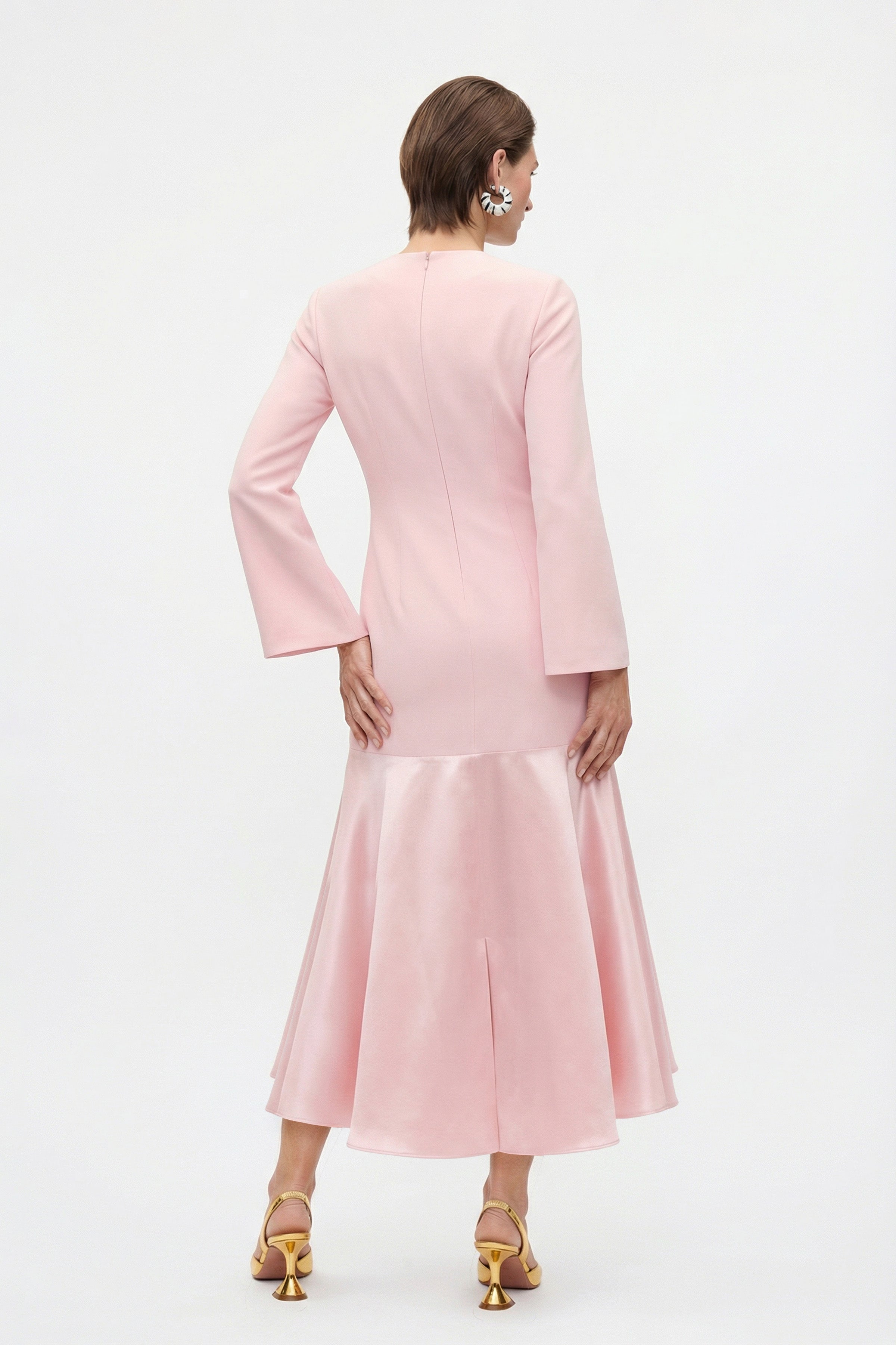 Back view of the model wearing the pink dress, highlighting the flowing silhouette and ankle-length cut.