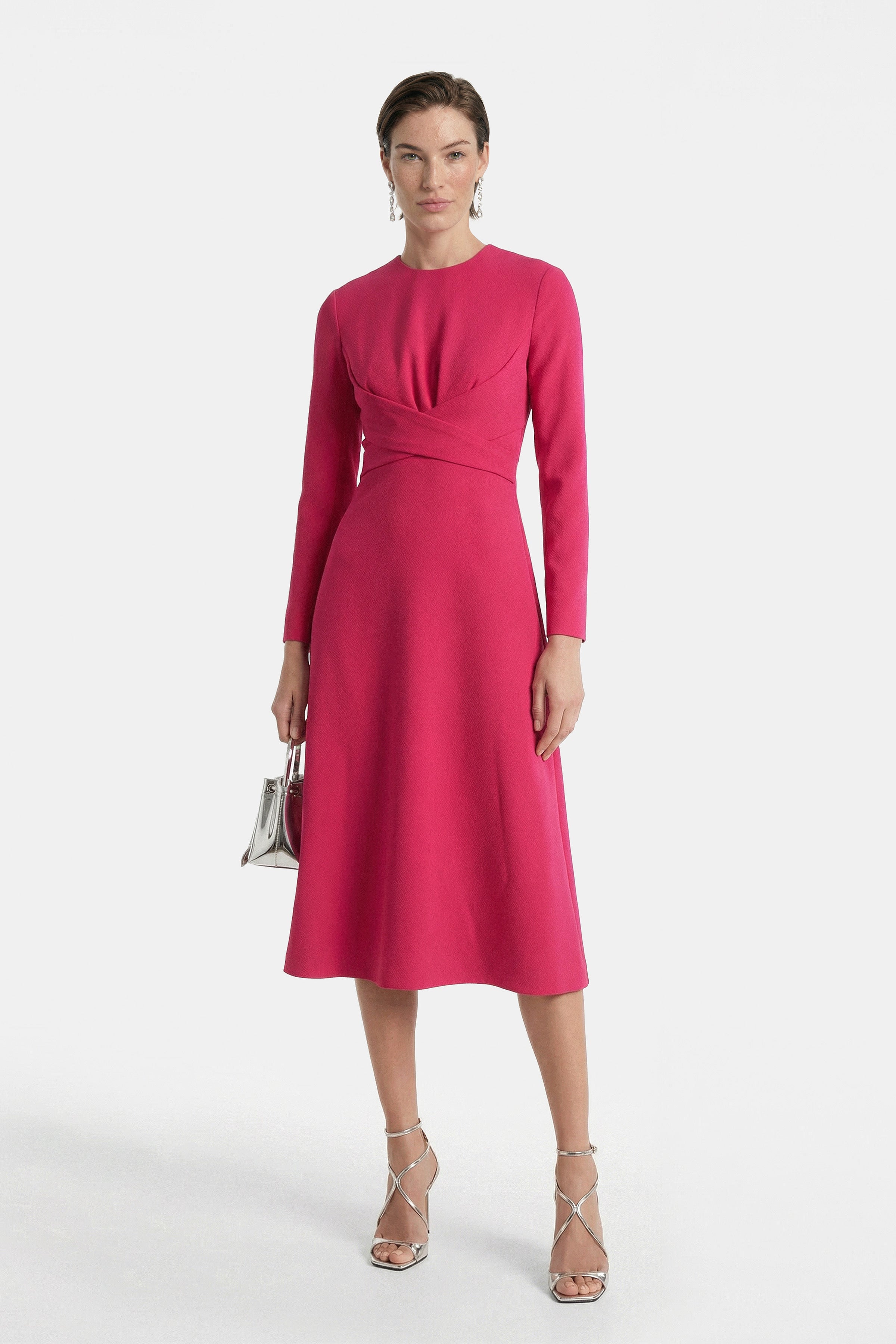 Front view of elegant fuchsia midi dress with long sleeves, model holding silver bag.