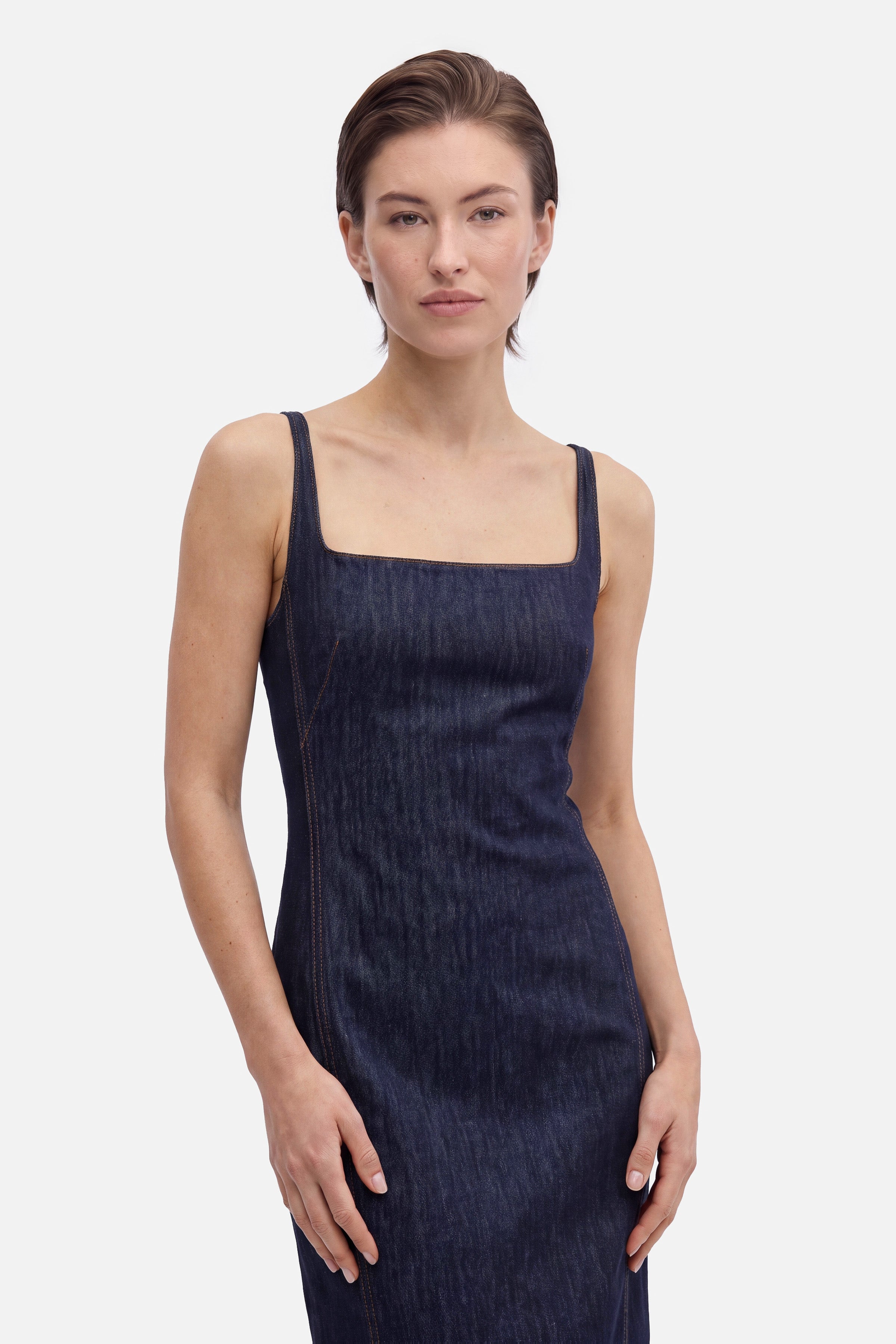 Front view of model in square neck denim midi dress, neutral expression.