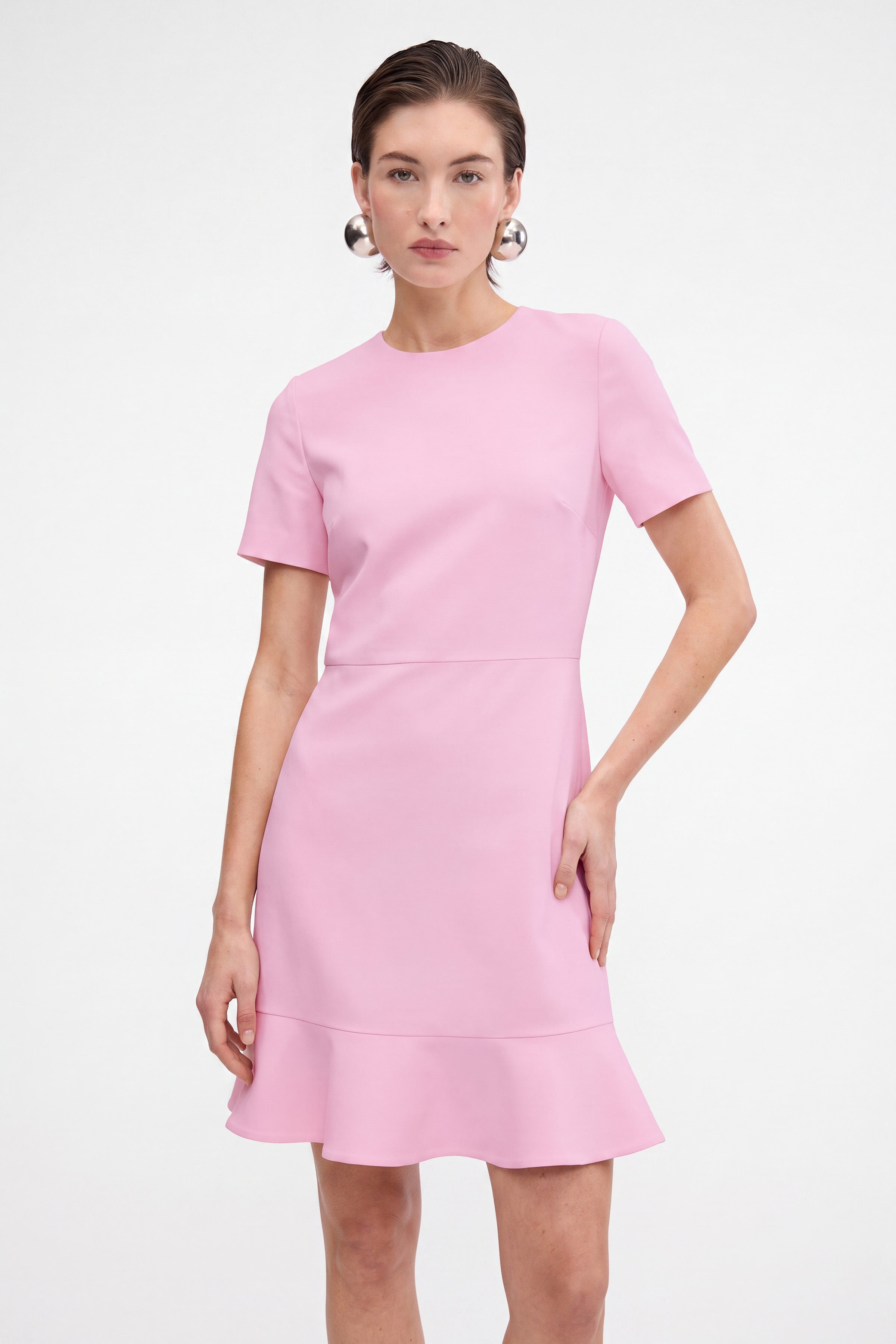 Front view of pink flounce hem dress with short sleeves, worn by model.