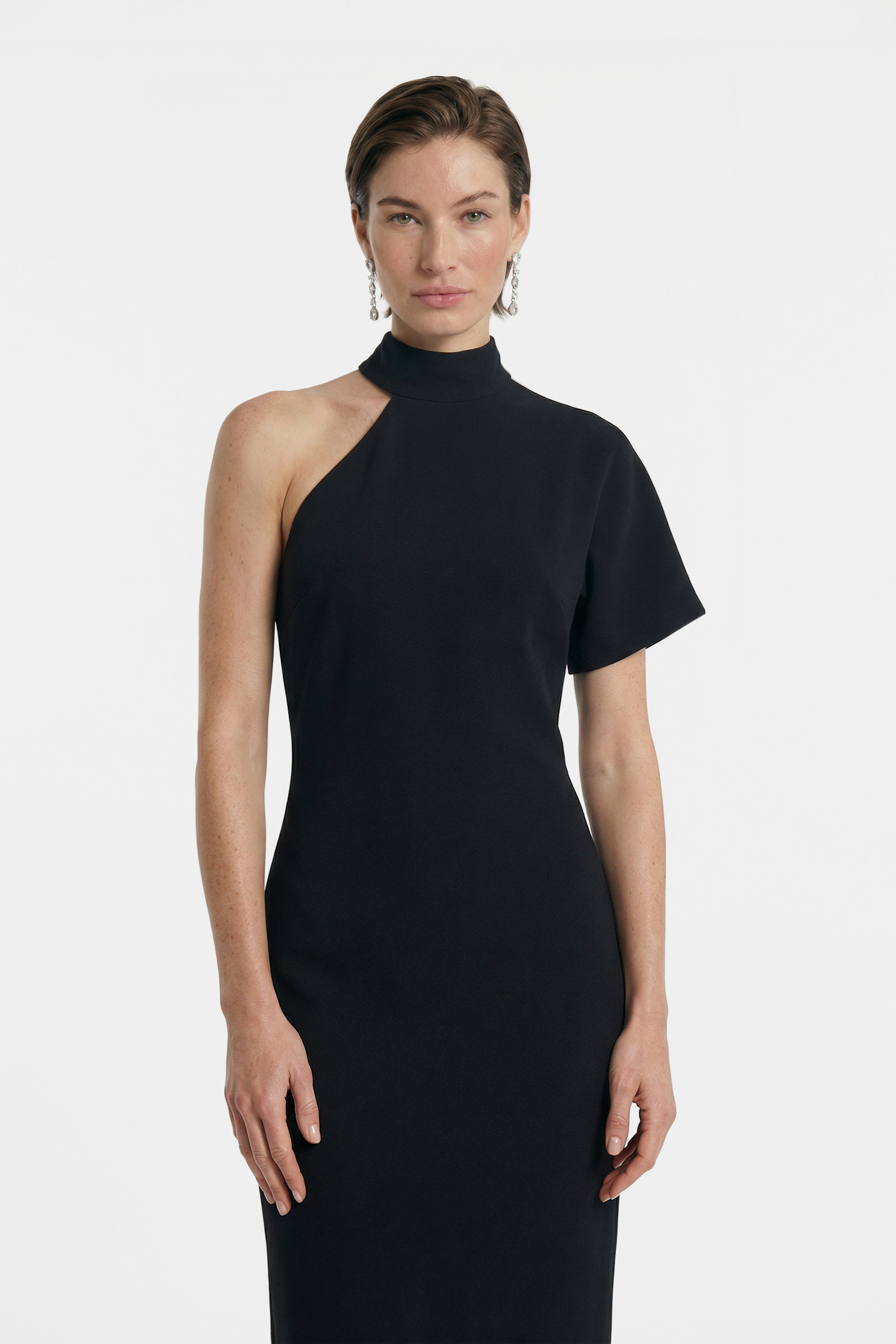 Front view of asymmetrical black midi dress with one sleeve, elegant fit.