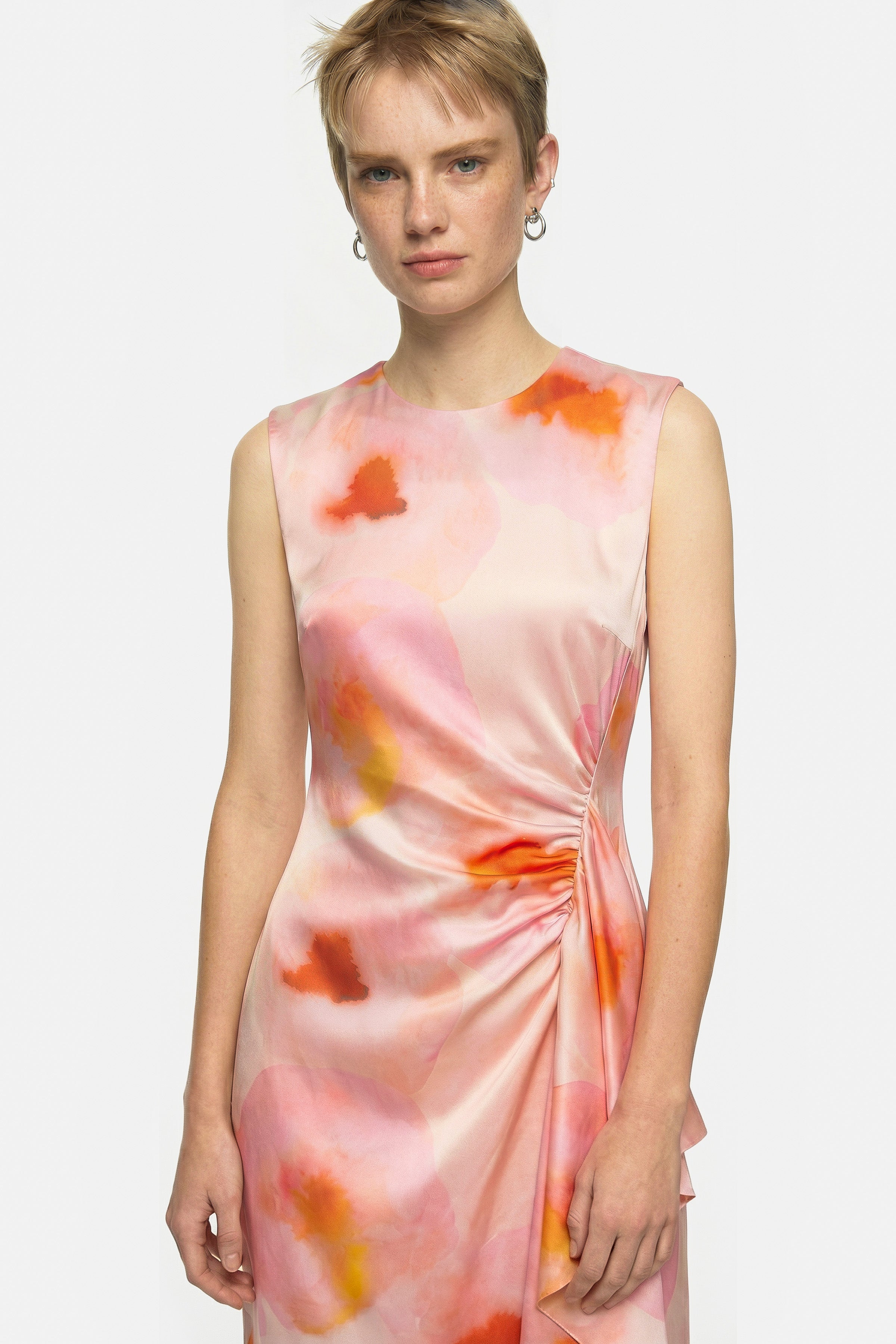 Front view of model wearing watercolor print midi dress with ruched detail.