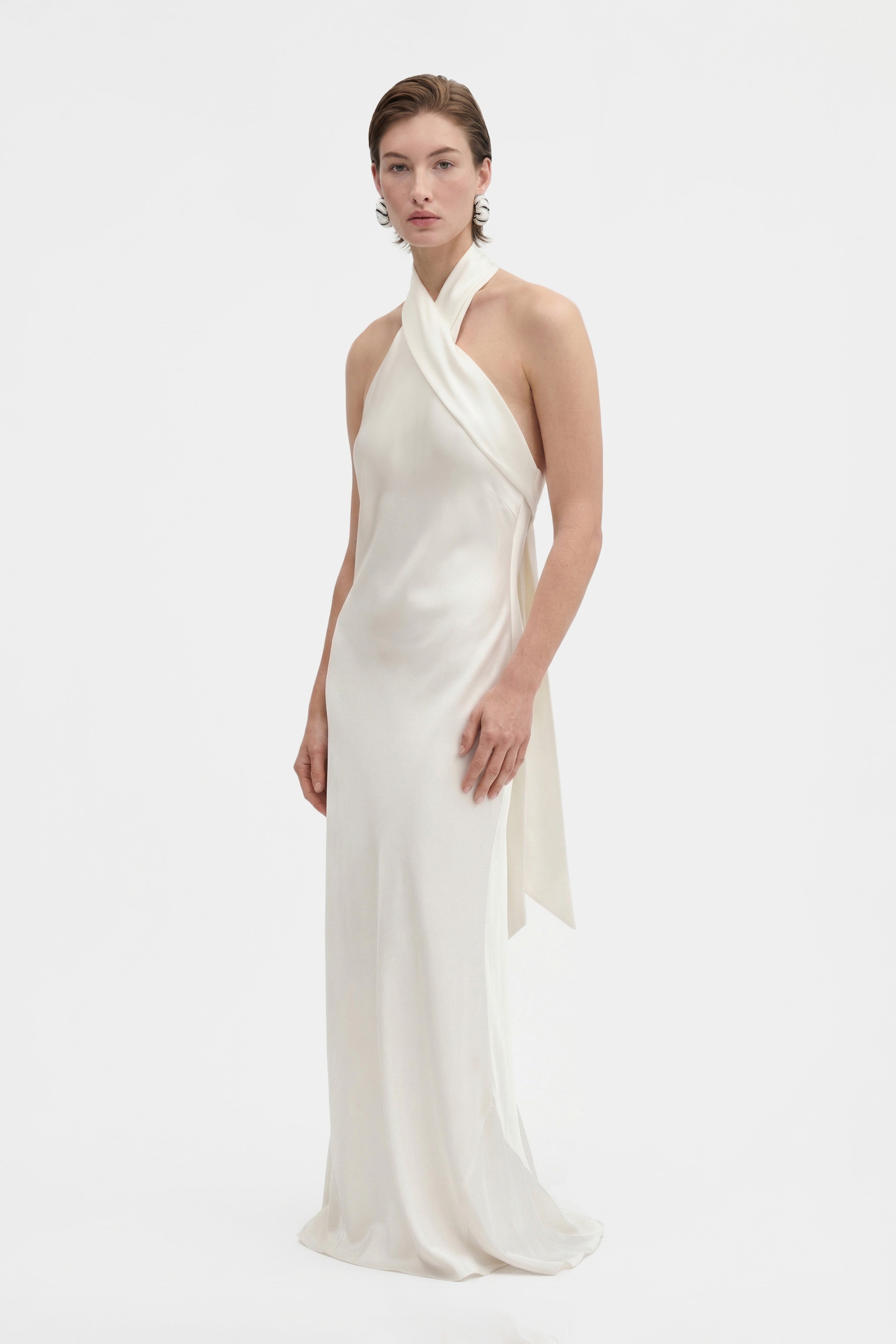 Elegant front view of ivory silk halter gown on model.