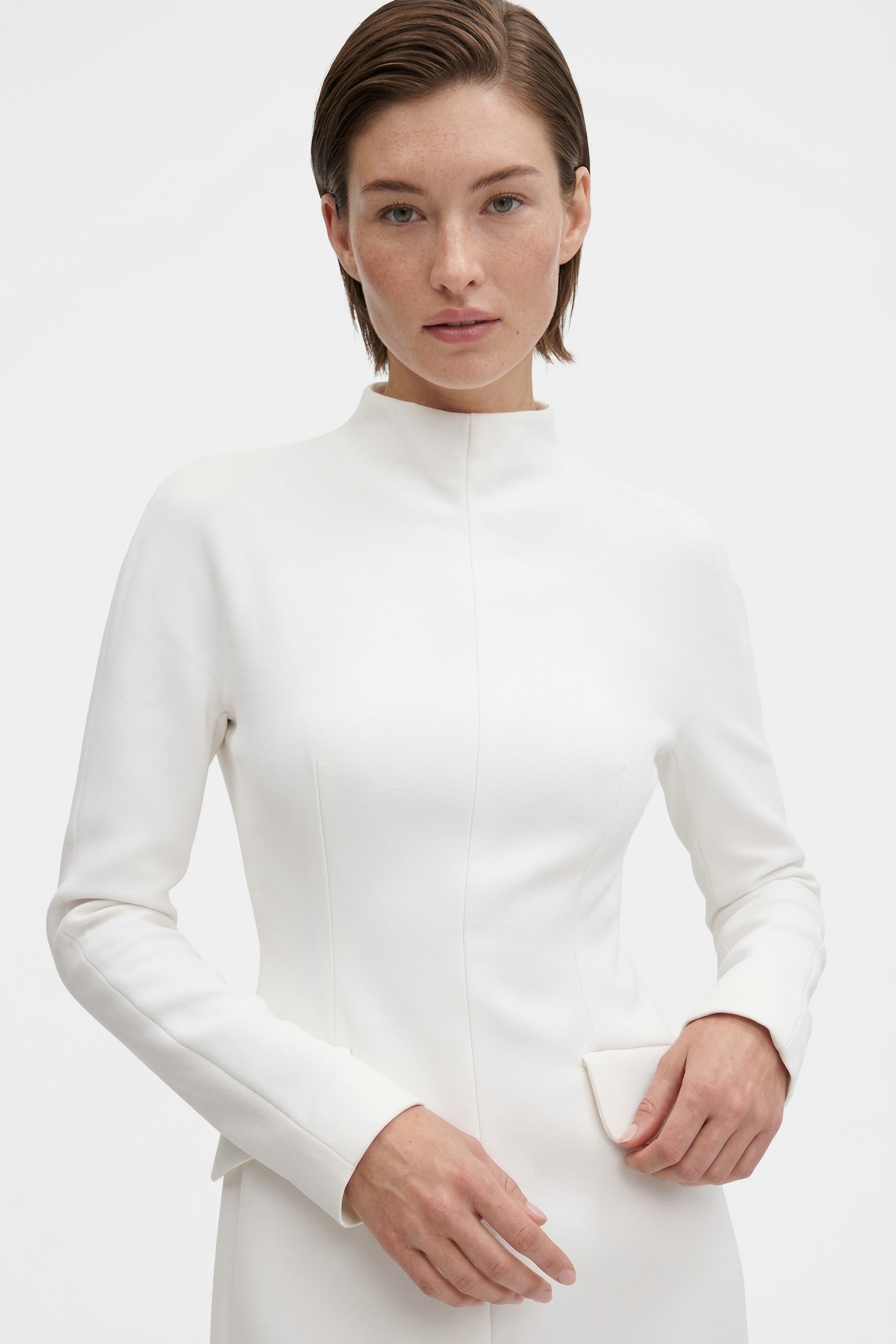 Front view of a white structured mini dress with high neckline detail.