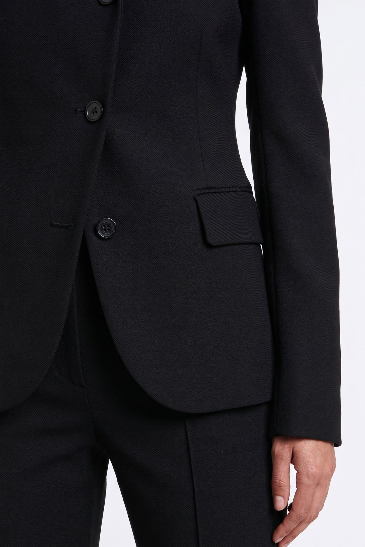Close-up of tailored black suit jacket with buttons and pocket detail.