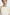 Front view of cream dress with ruffle detail on shoulder, worn by model.