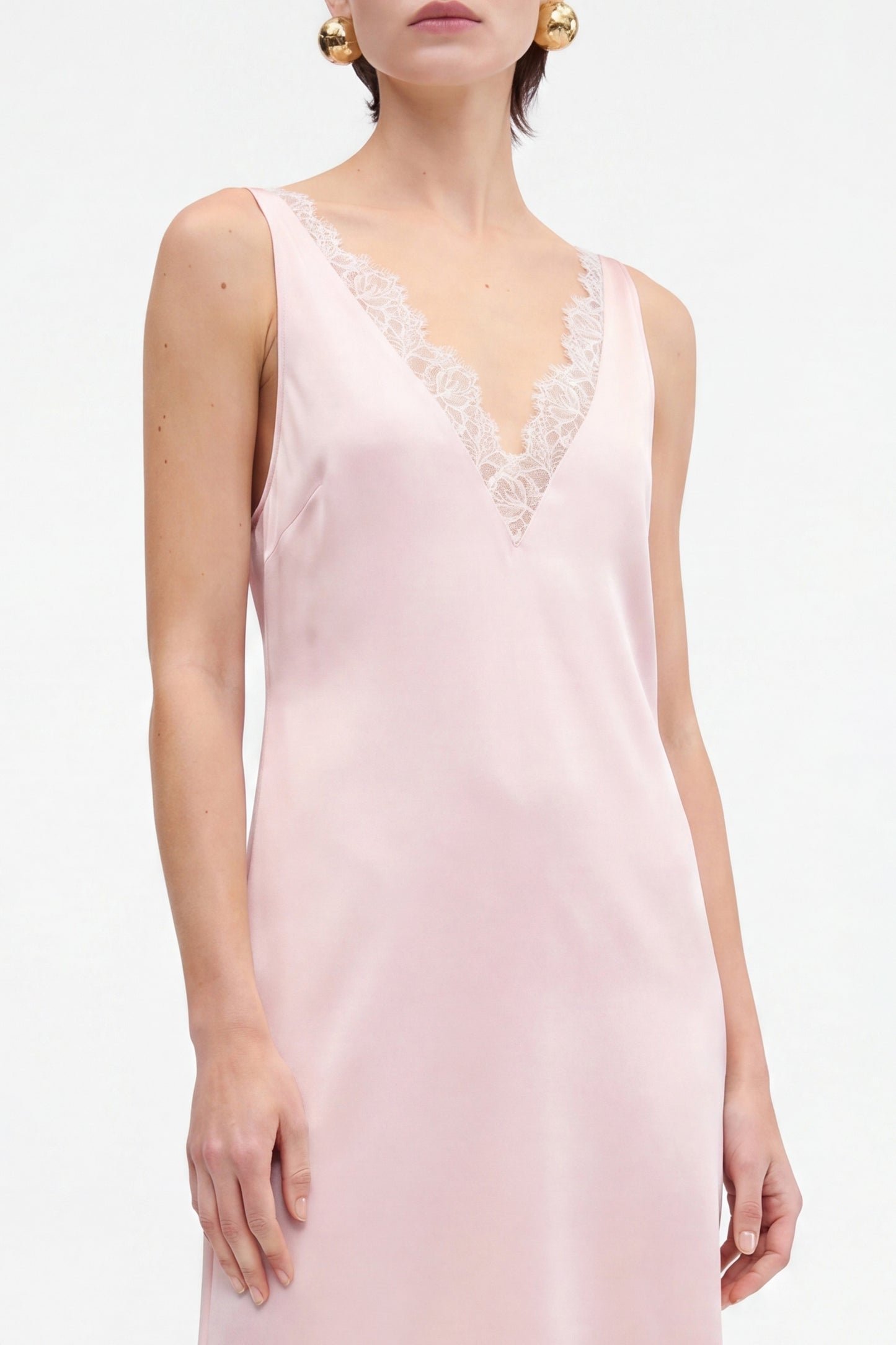 Blush lace slip dress with V-neck, delicate lace trim, sleeveless, model's front view.