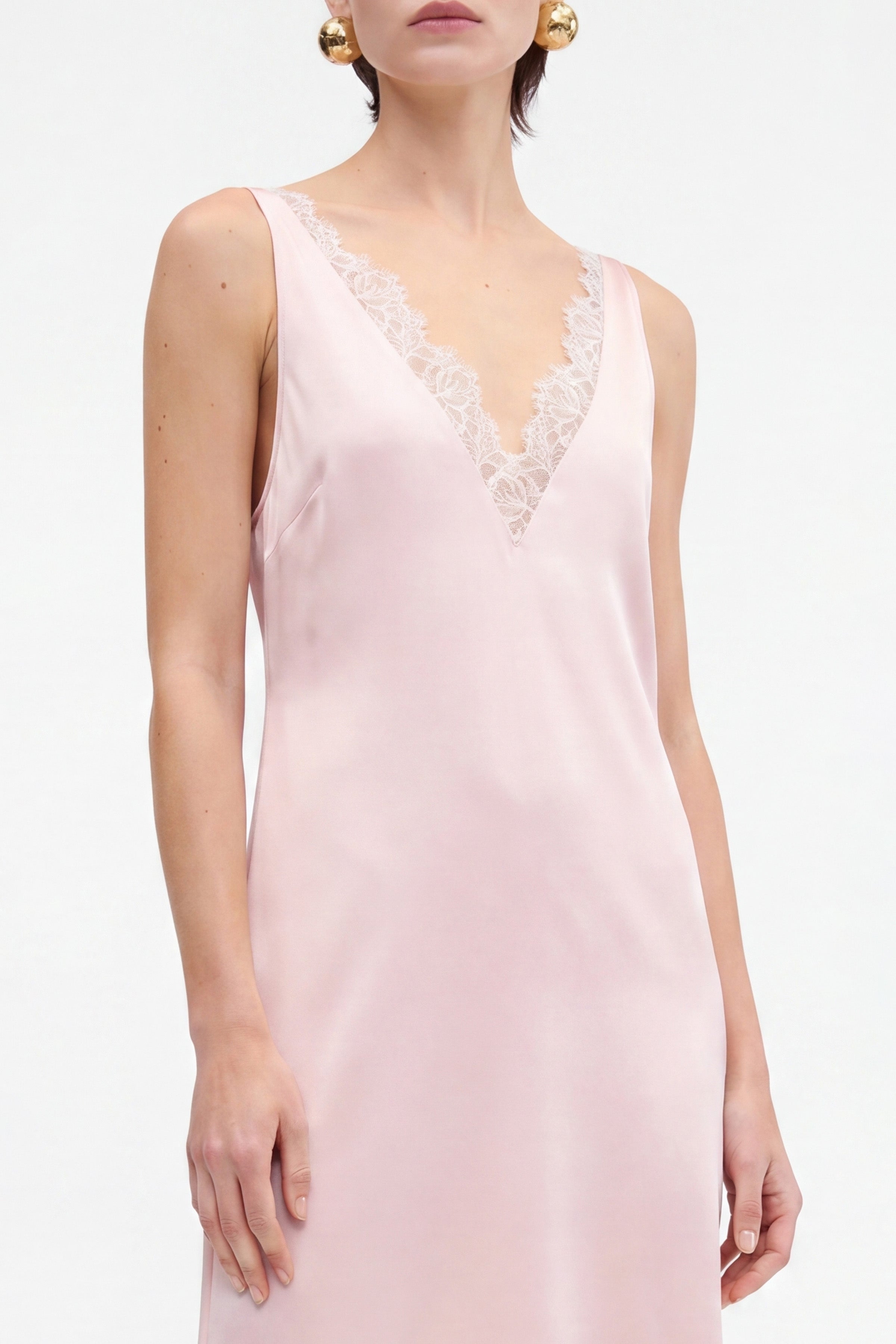 Blush lace slip dress with V-neck, delicate lace trim, sleeveless, model's front view.