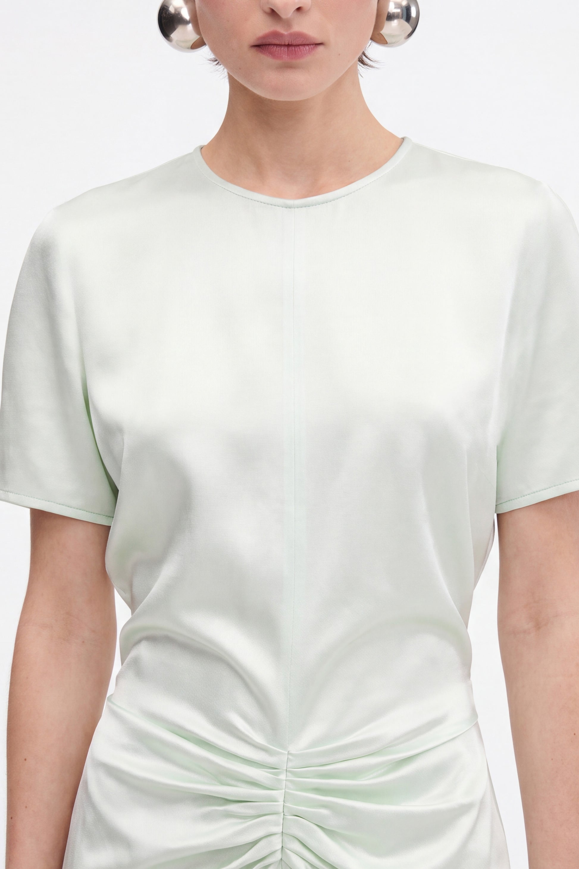 Front view of mint satin dress with ruched detail, worn by model.