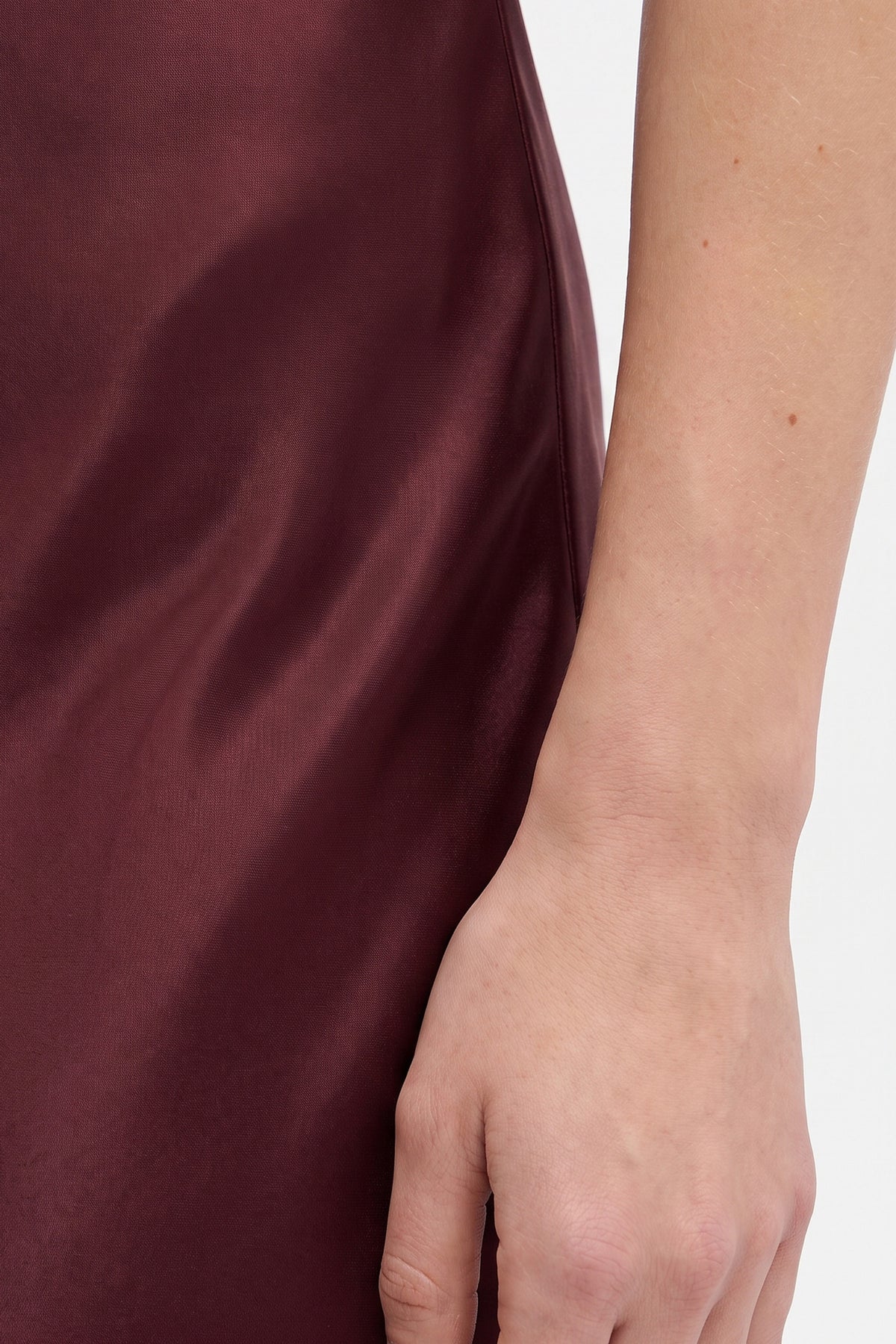 Close-up of a burgundy strapless gown fabric and side view detail.
