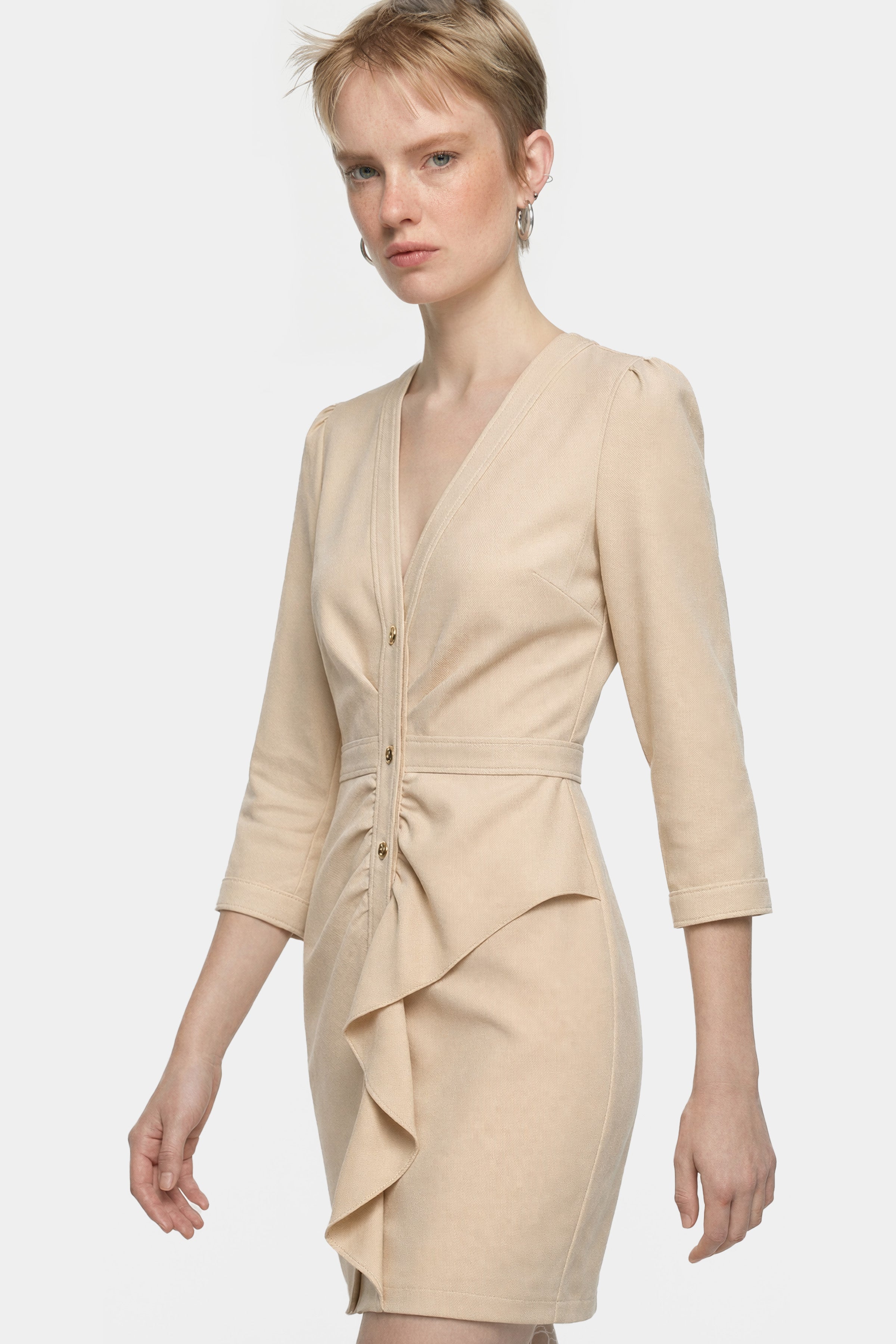 Model in beige ruffle button dress, V-neck, three-quarter sleeves, front view.