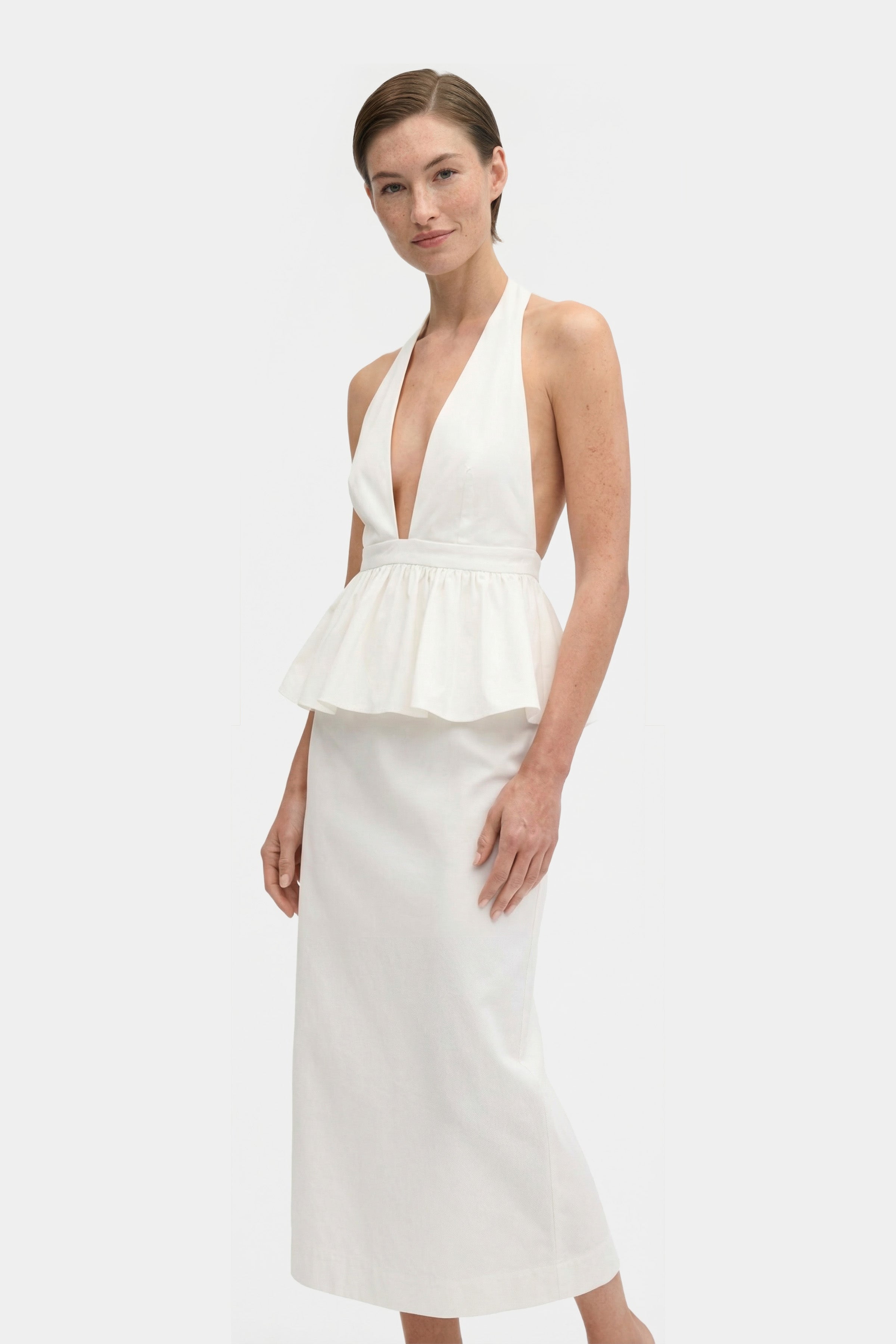 White halter peplum dress, front view, deep V-neckline, worn by model.