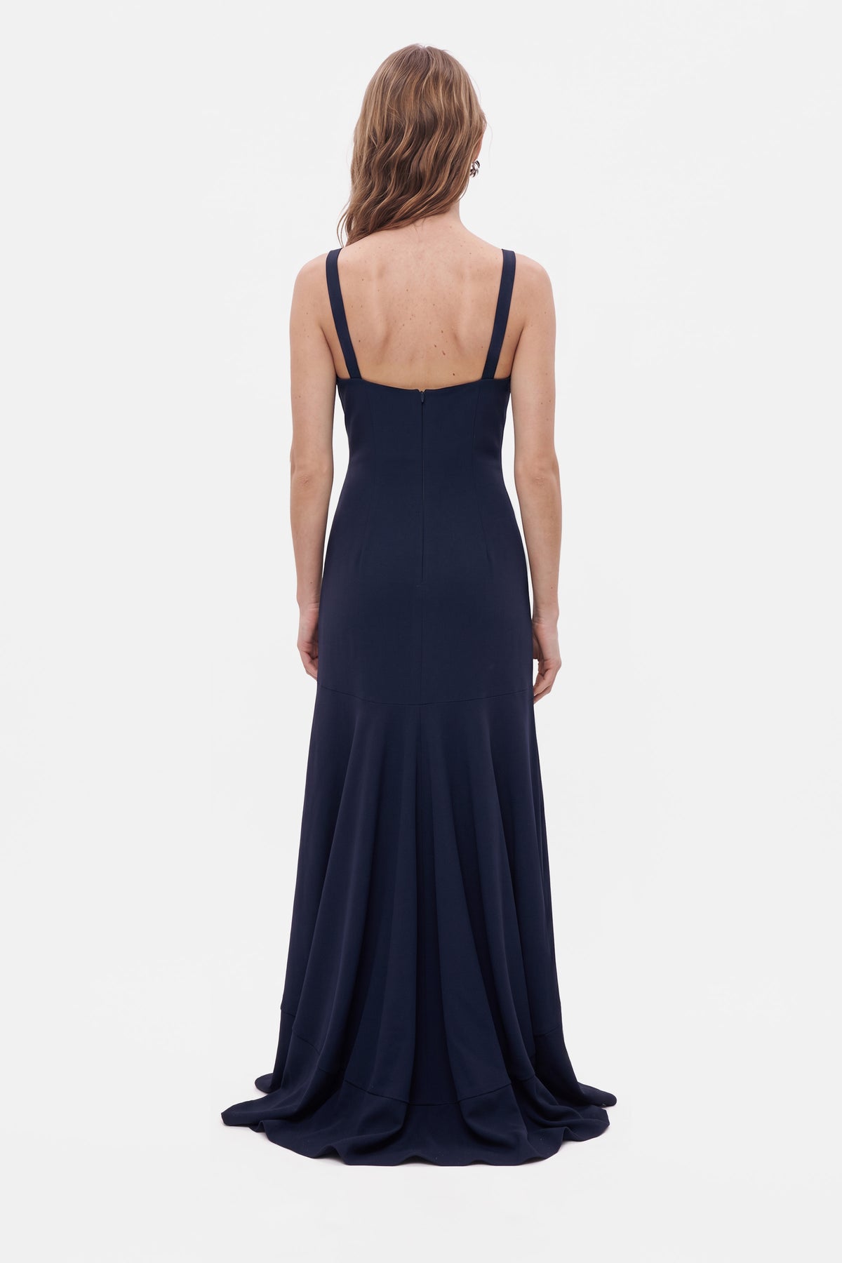Back view of a navy ruffle hem gown with thin straps and elegant flow.