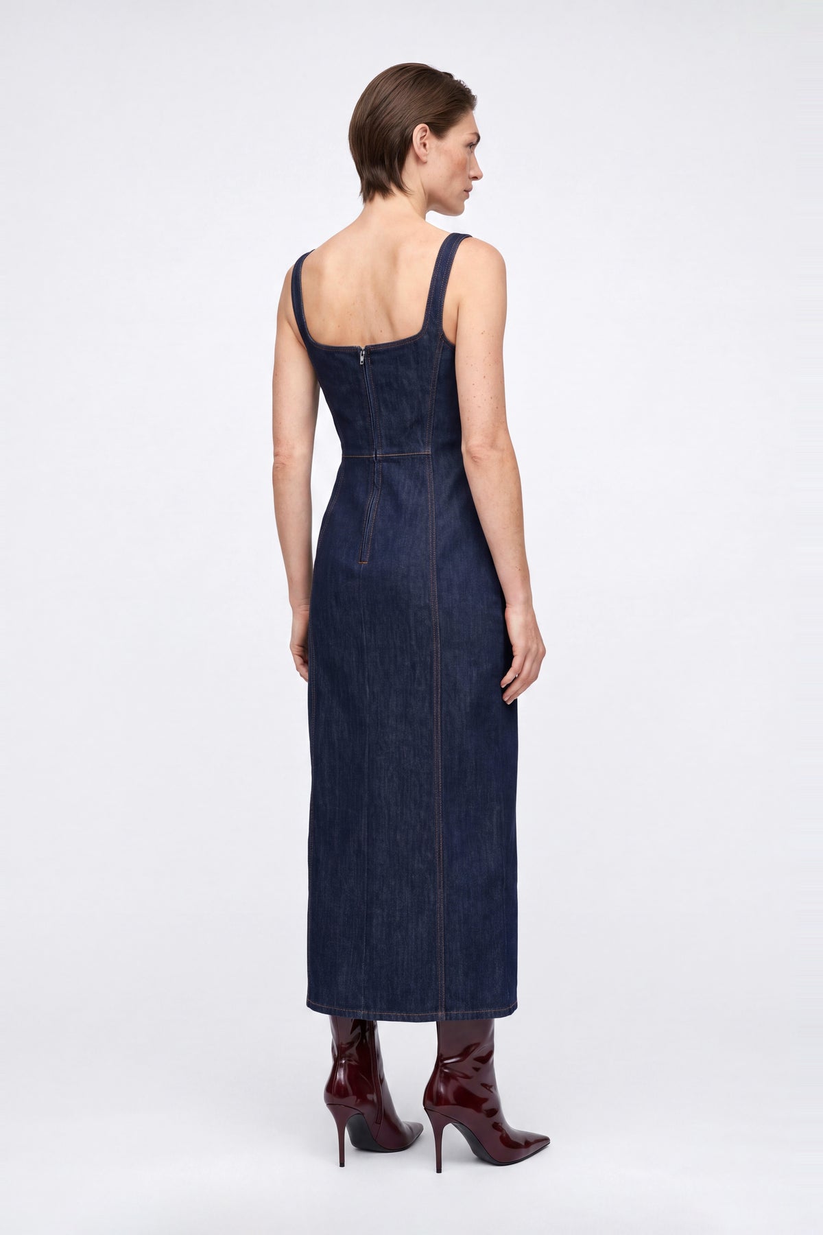 Back view of denim square neck midi dress, showing zipper and red heeled boots.