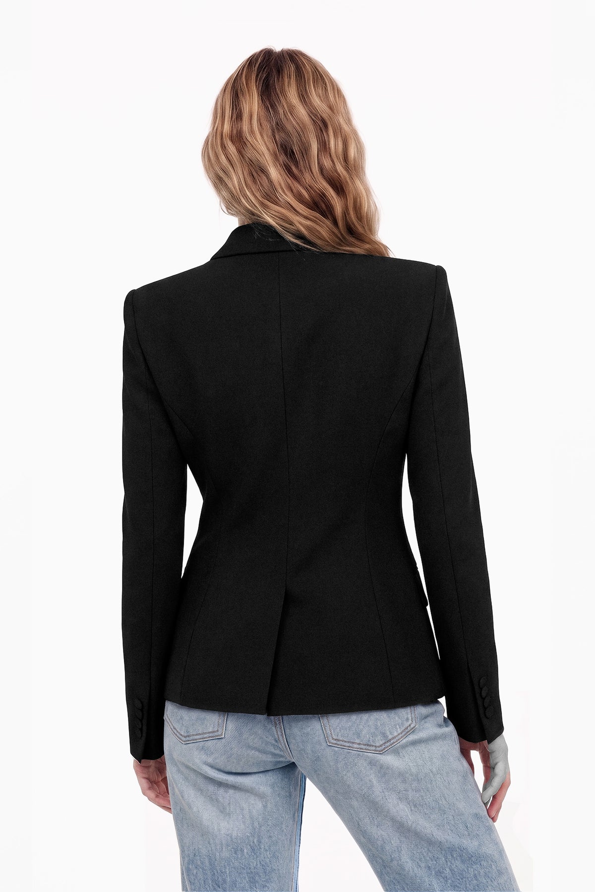 Back view of structured black blazer, model in jeans, soft lighting.