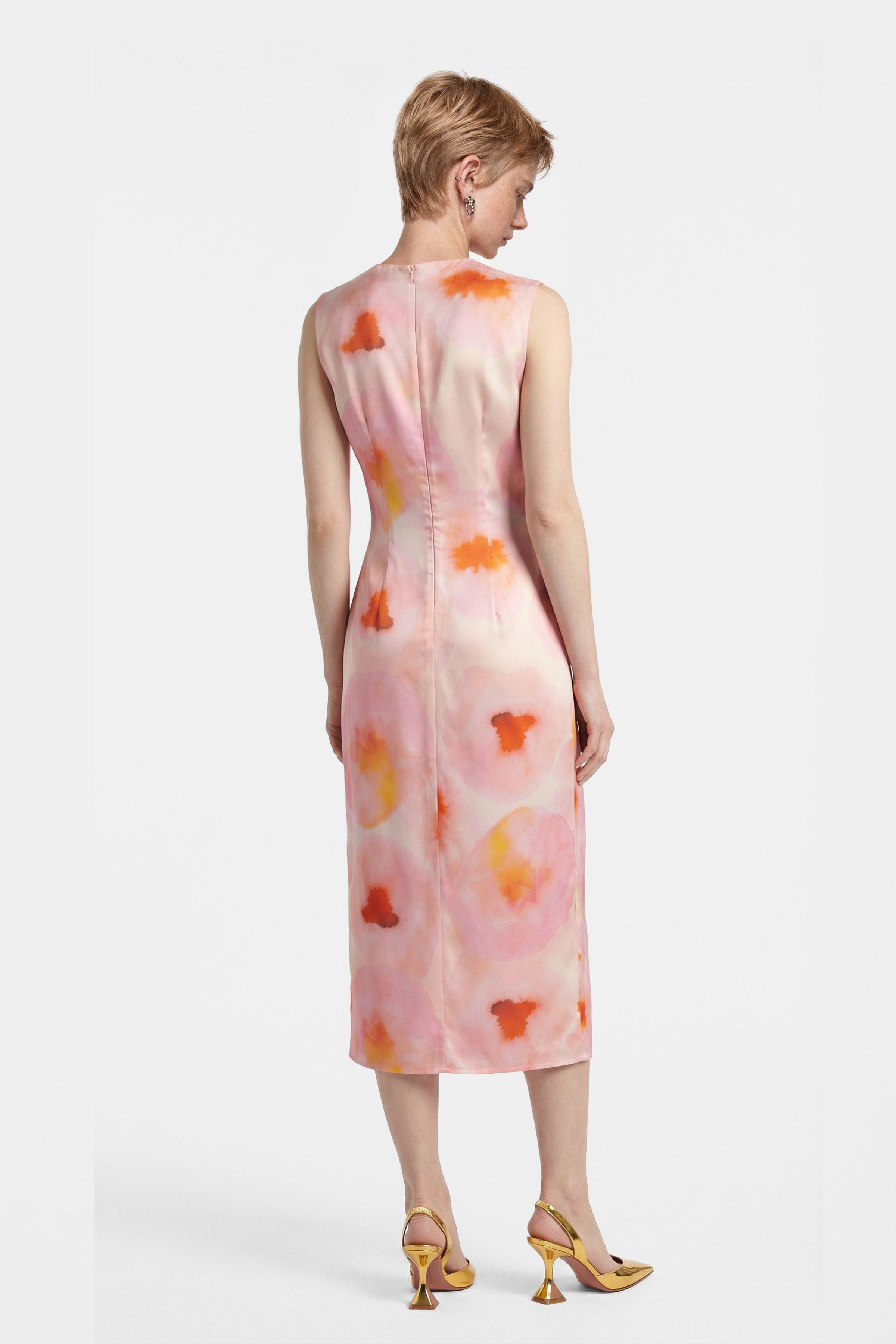 Back view of watercolor print midi dress, sleeveless, worn with yellow heels.