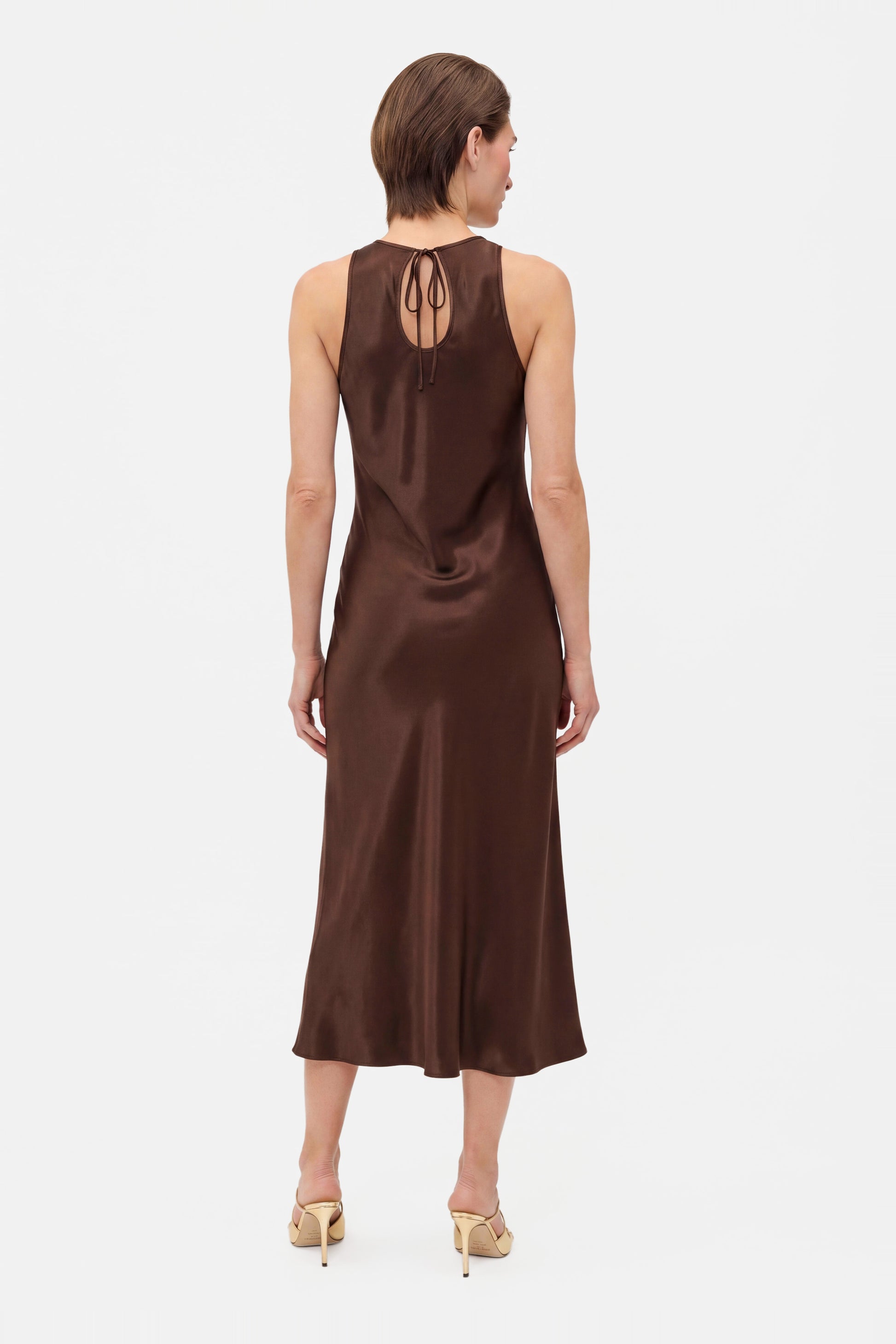 Back view of chocolate satin midi dress with tie detail, worn by model.